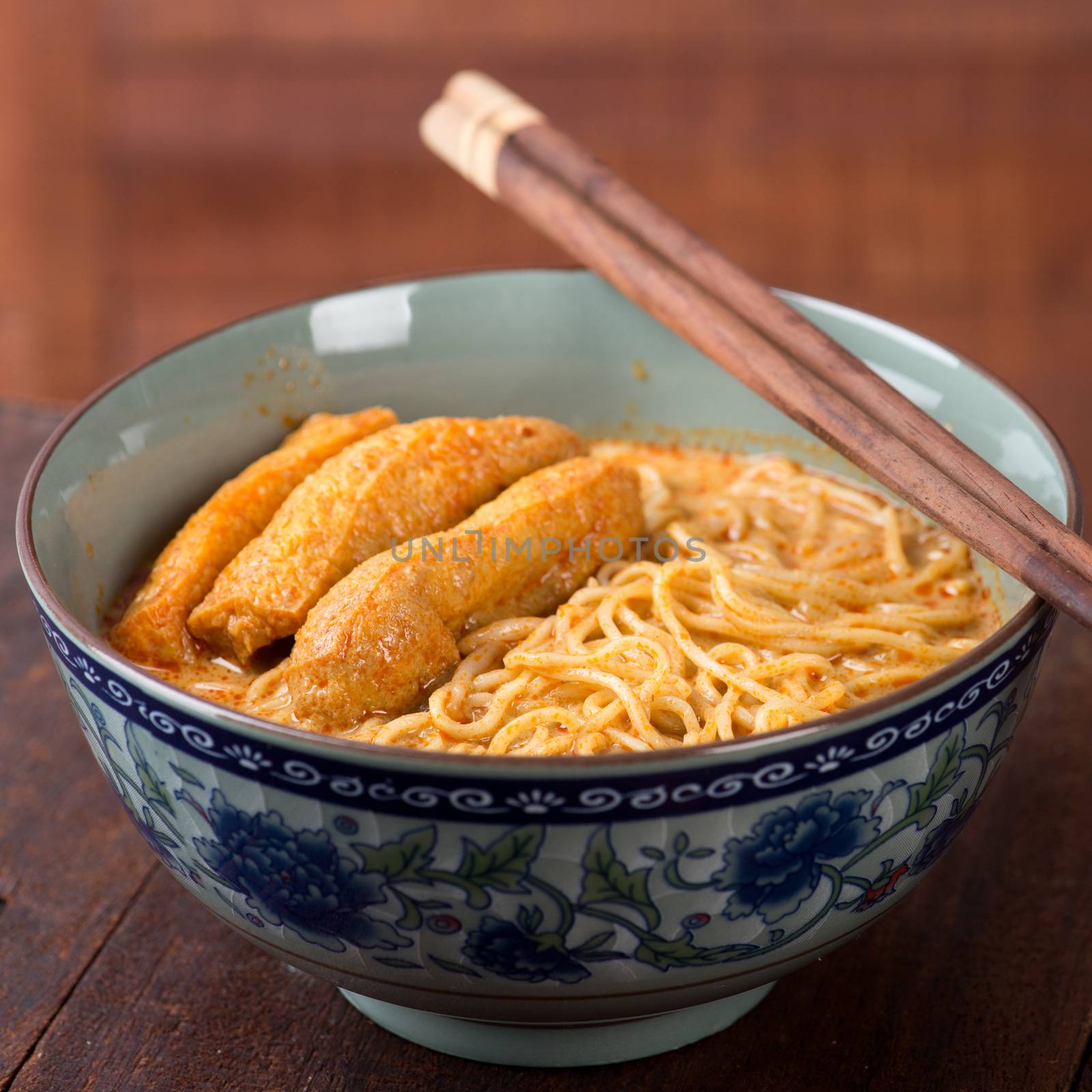 Hot and spicy curry noodle with chopsticks on the table, popular foods in Asia.