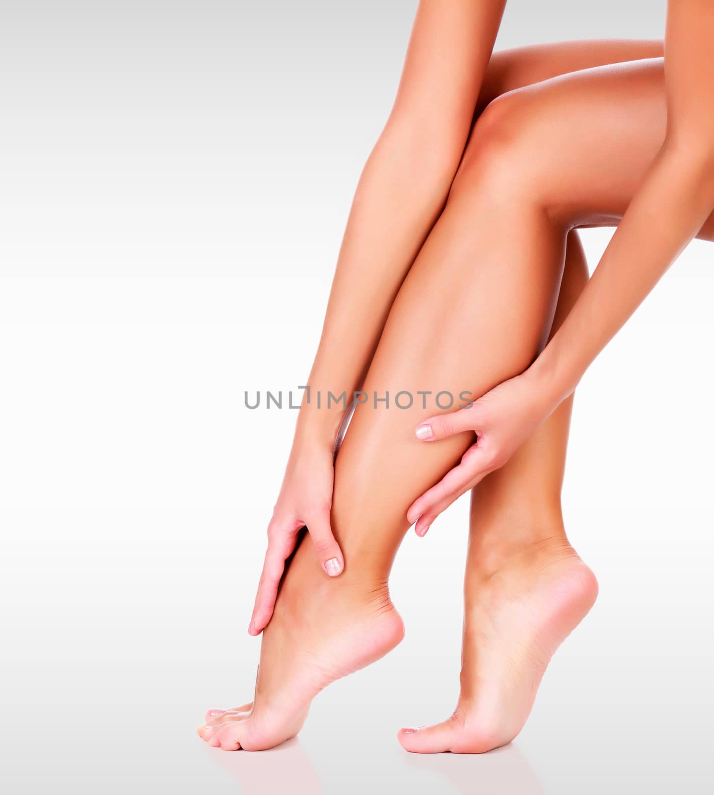 Closeup shot of beautiful female legs and hands. Unwanted hair removal concept. Perfect smooth skin