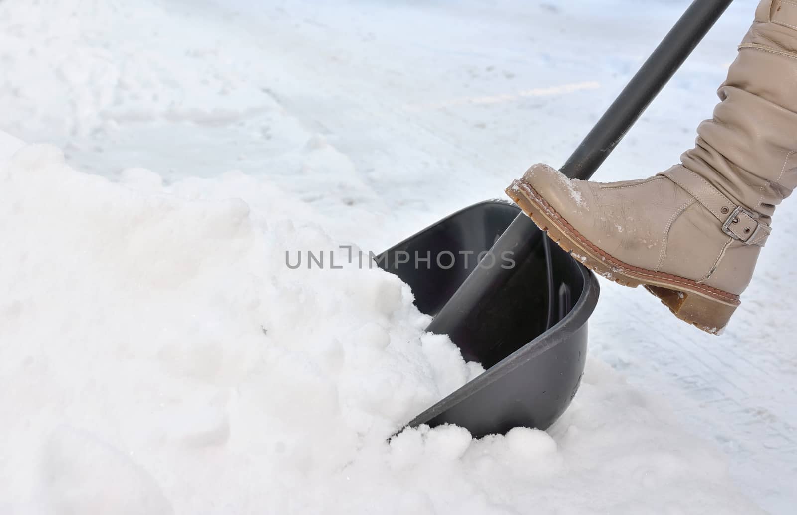 Woman Shoveling snow on street  in winter
