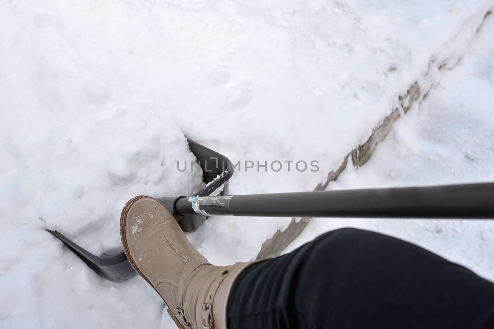 Woman Shoveling snow on street 