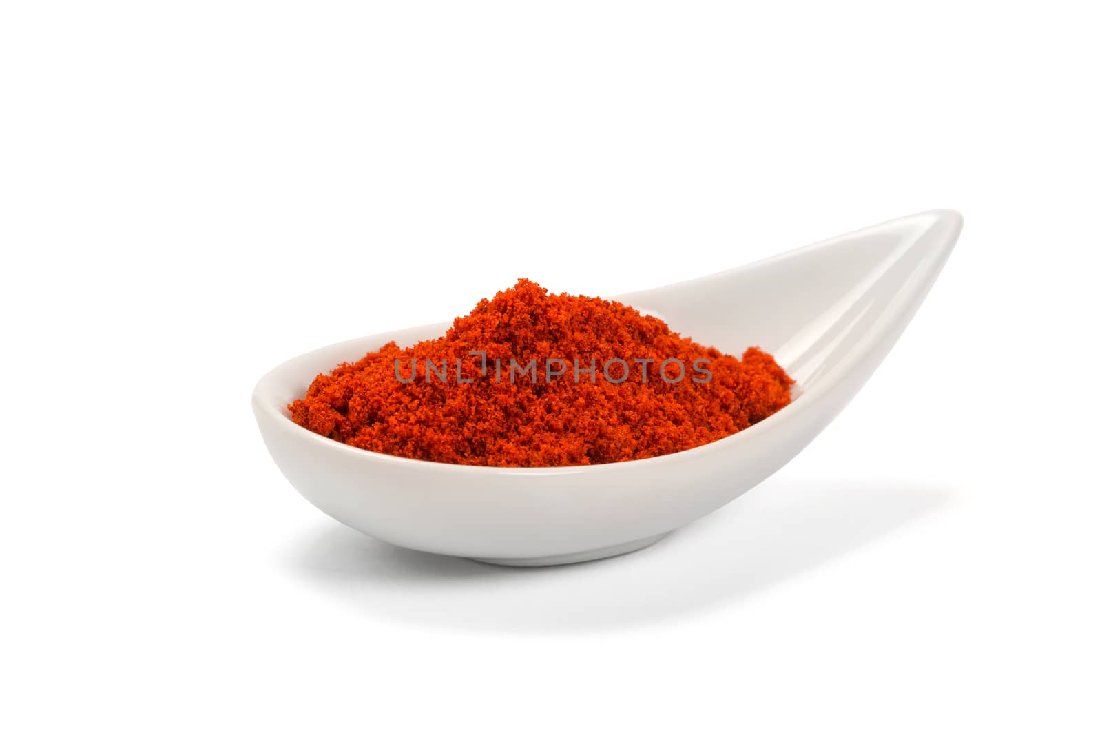 Bowl of ground red pepper spice in bowl isolated on white.