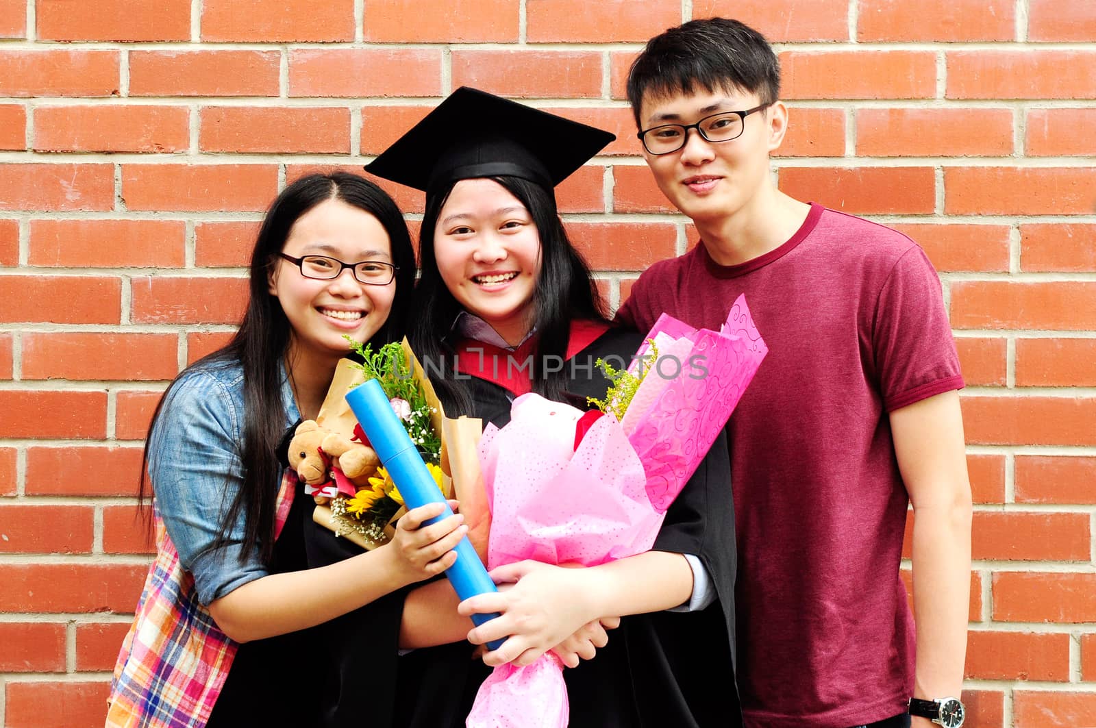 Asian university student and family celebrating graduation outdoor