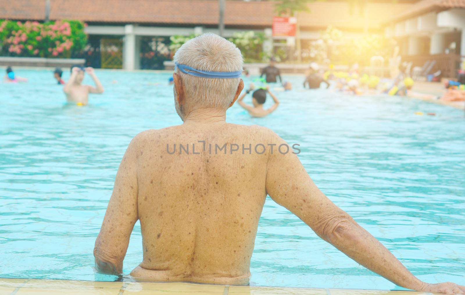 back of senior man on the side of swimming pool