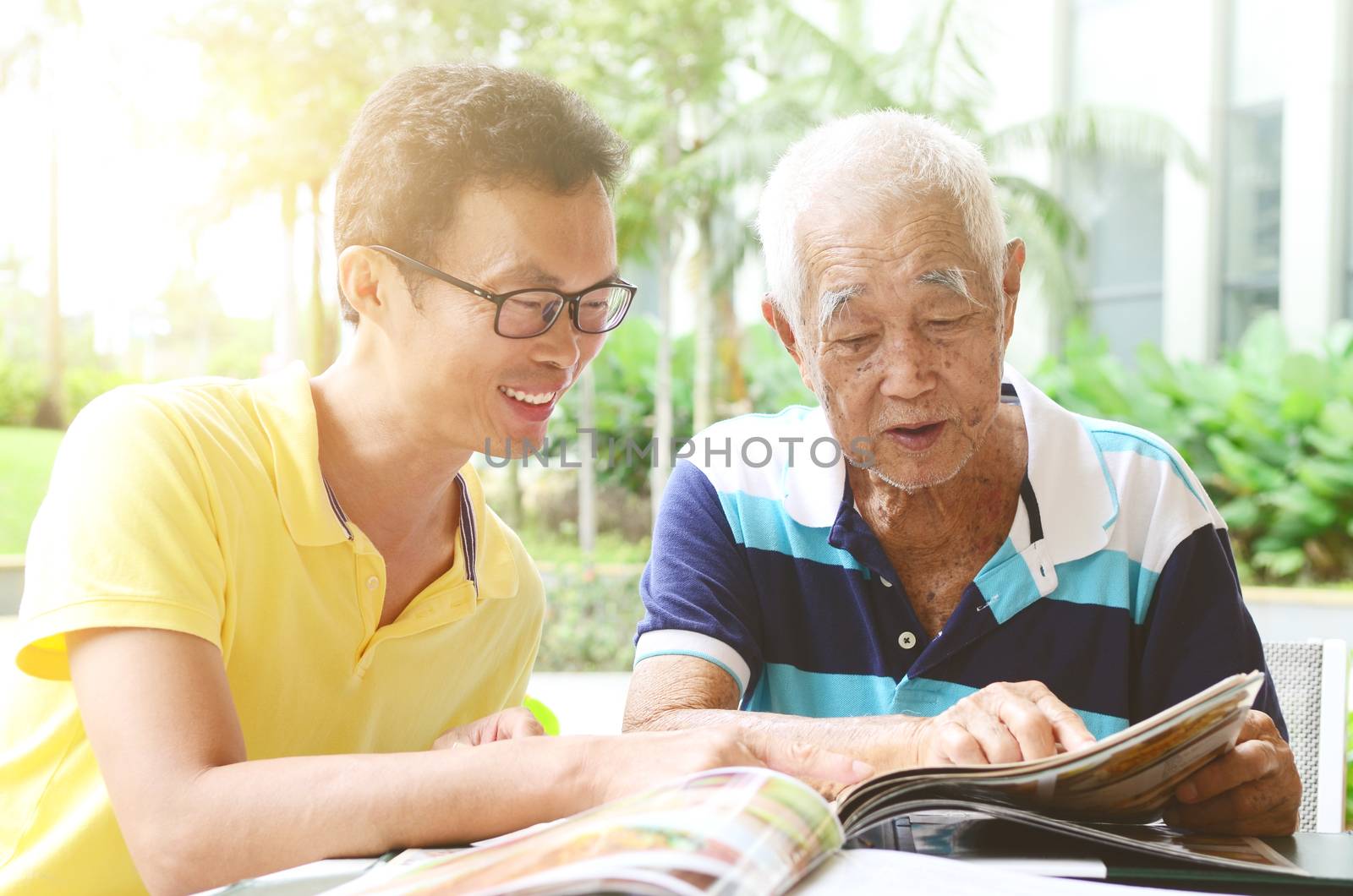 Asian senior man and son in the restaurant,ordering food by looking at the menu.