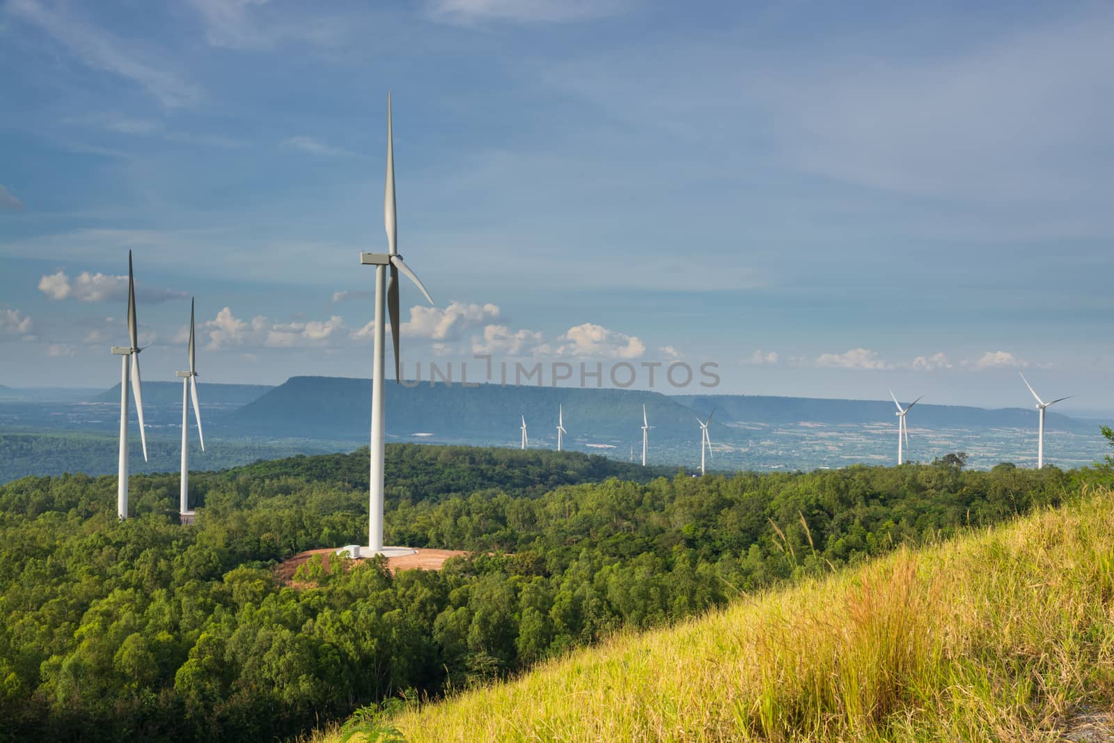 Wind Turbine Power Generator in WindPower Field or Farm with Blue Sky as Electrical efficiency or Renewable Power Technology Business Concept.