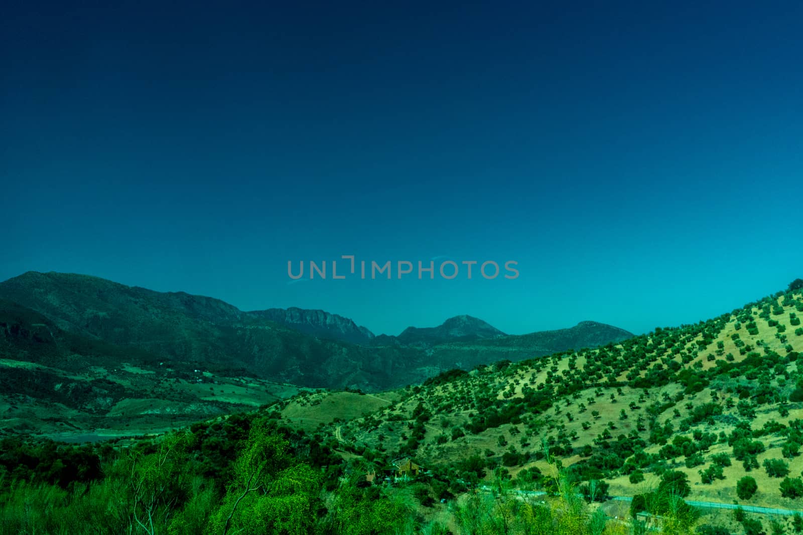 Greenery, Mountains, Farms and Fields on the outskirts of Ronda Spain, Europe on a hot summer day with clear blue skies