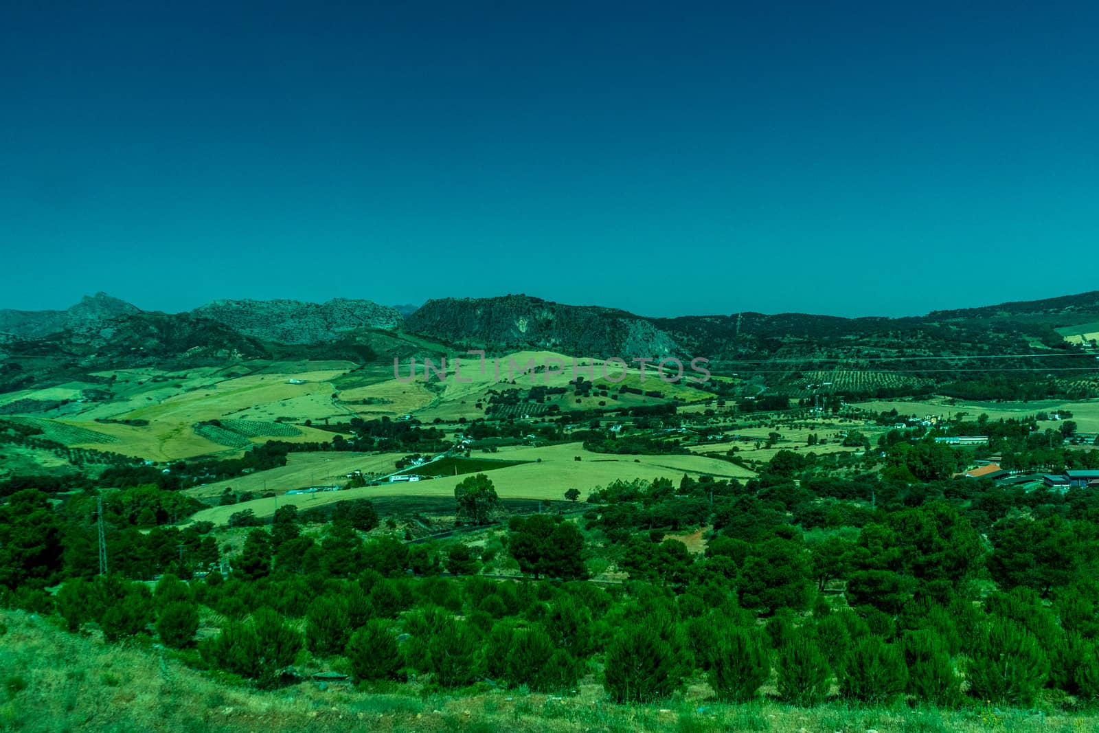 Greenery, Mountains, Farms and Fields on the outskirts of Ronda Spain, Europe on a hot summer day with clear blue skies