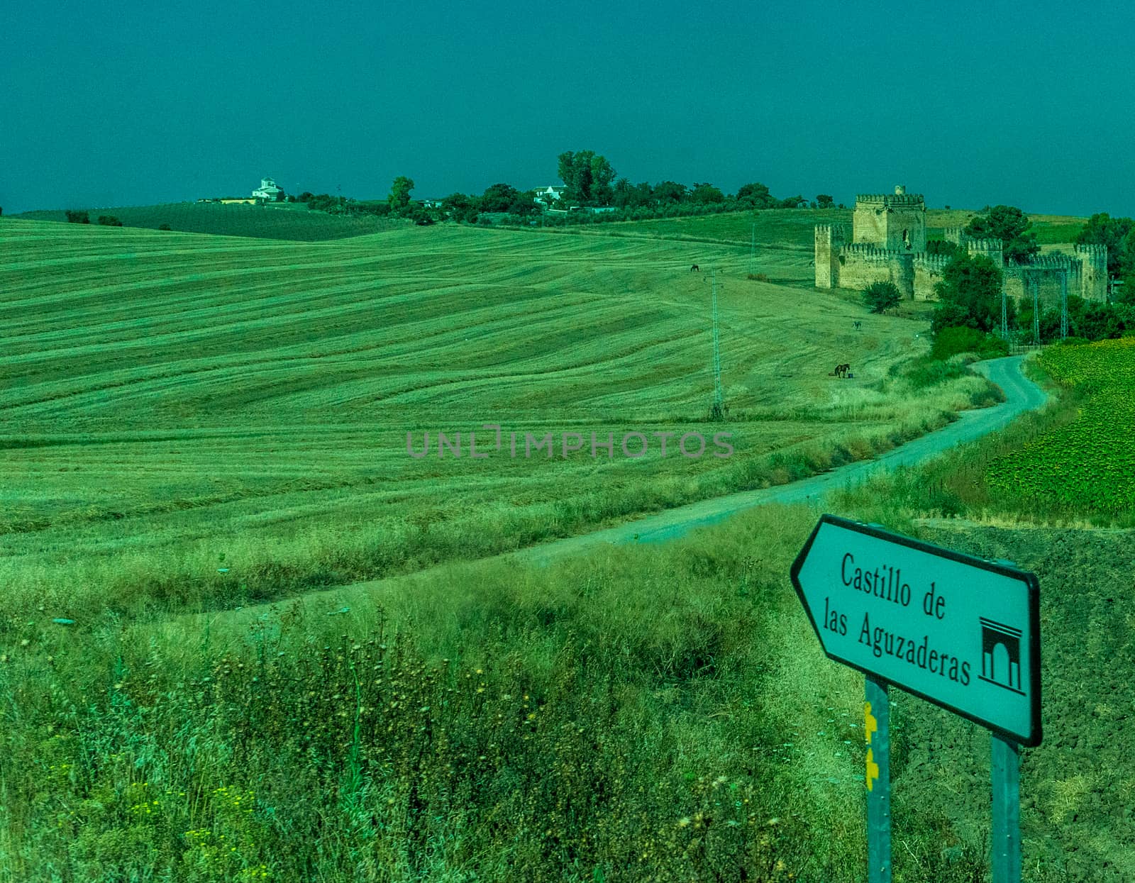 Castle, Greenery, Mountains, Farms and Fields on the outskirts of Ronda Spain, Europe on a hot summer day with clear blue skies