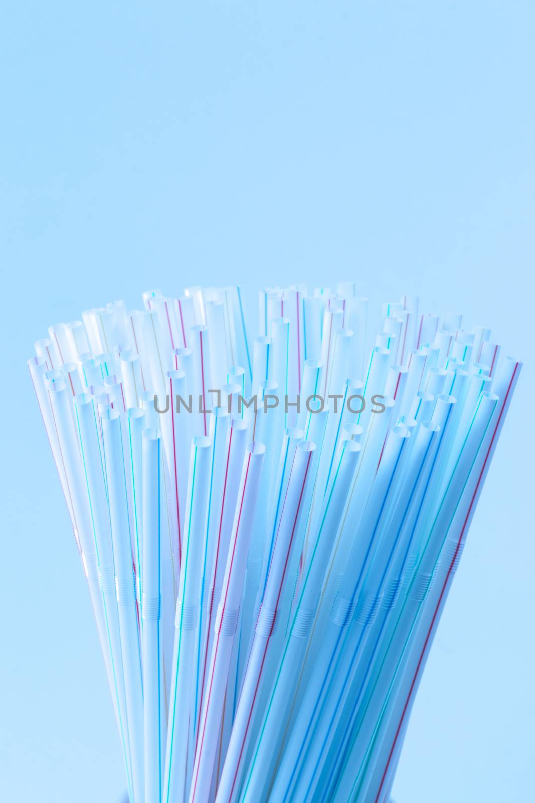 Bunch of drinking straws isolated on a blue background.
