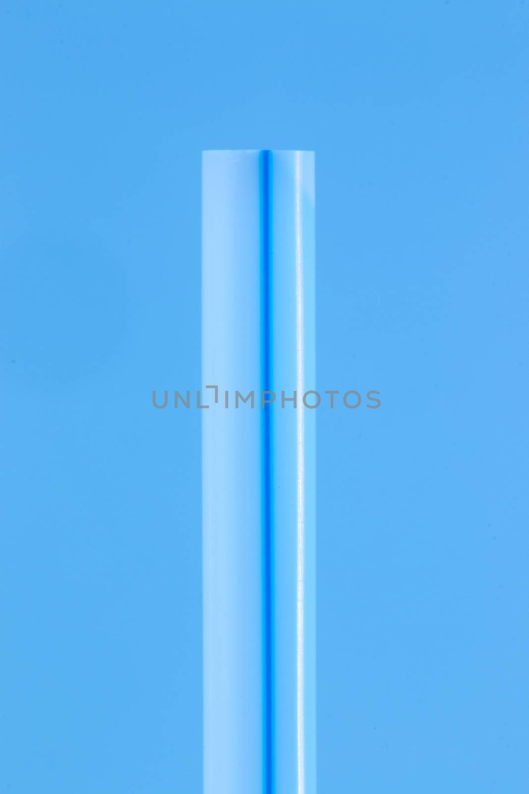 drinking straw close up macro detail  isolated on a blue background.