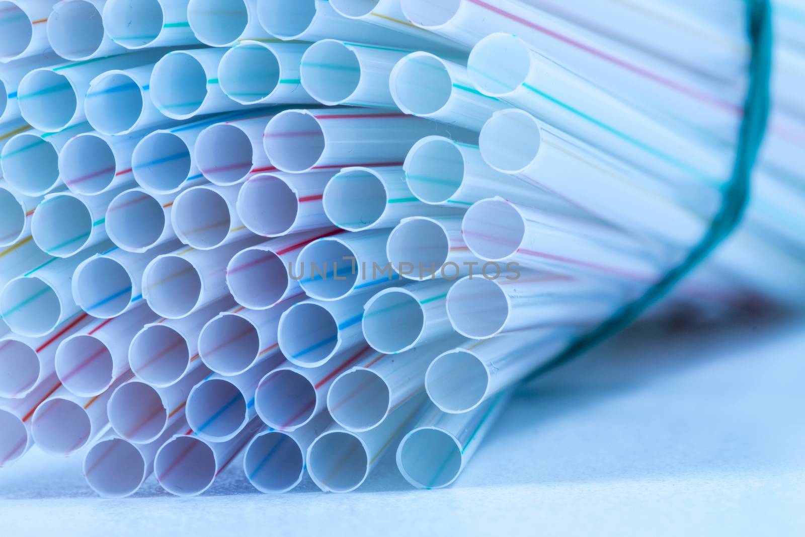 Bunch of drinking straws isolated on a blue background.