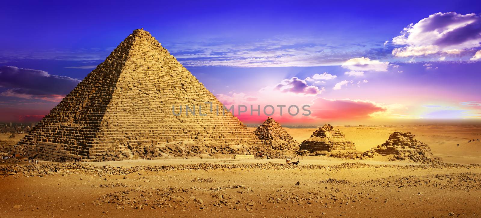 Pyramids in desert under ultra violet clouds