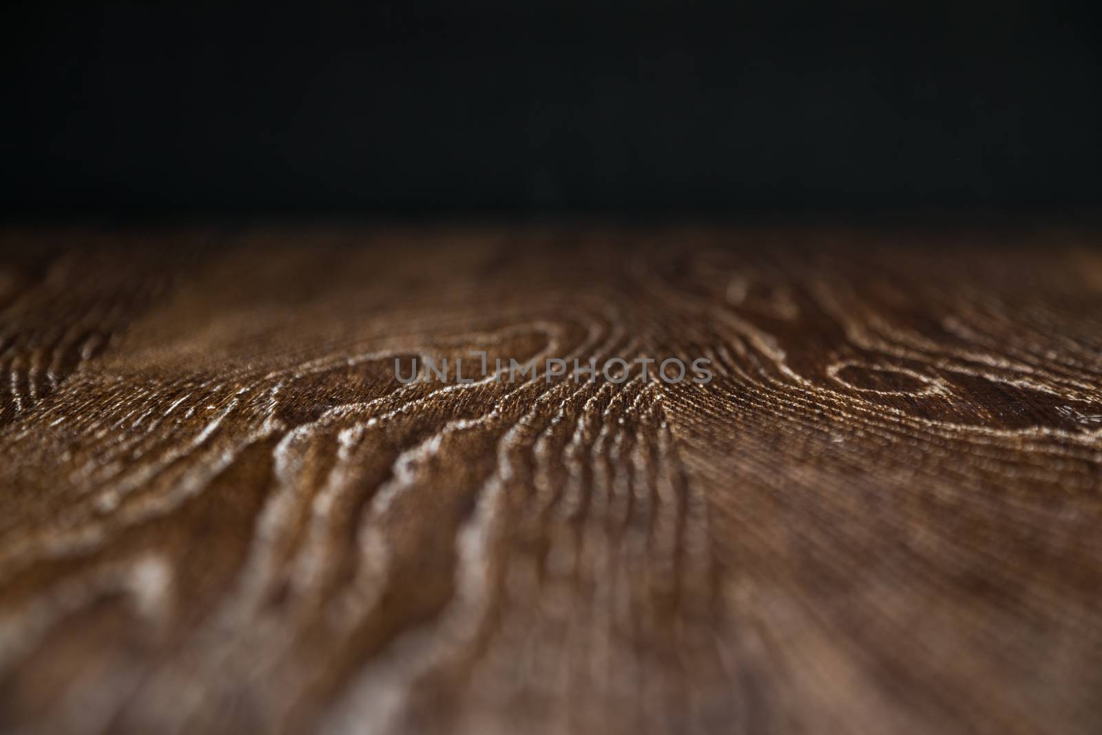 Wooden Background Surface with Narrow Depth of Field Fading to Black.