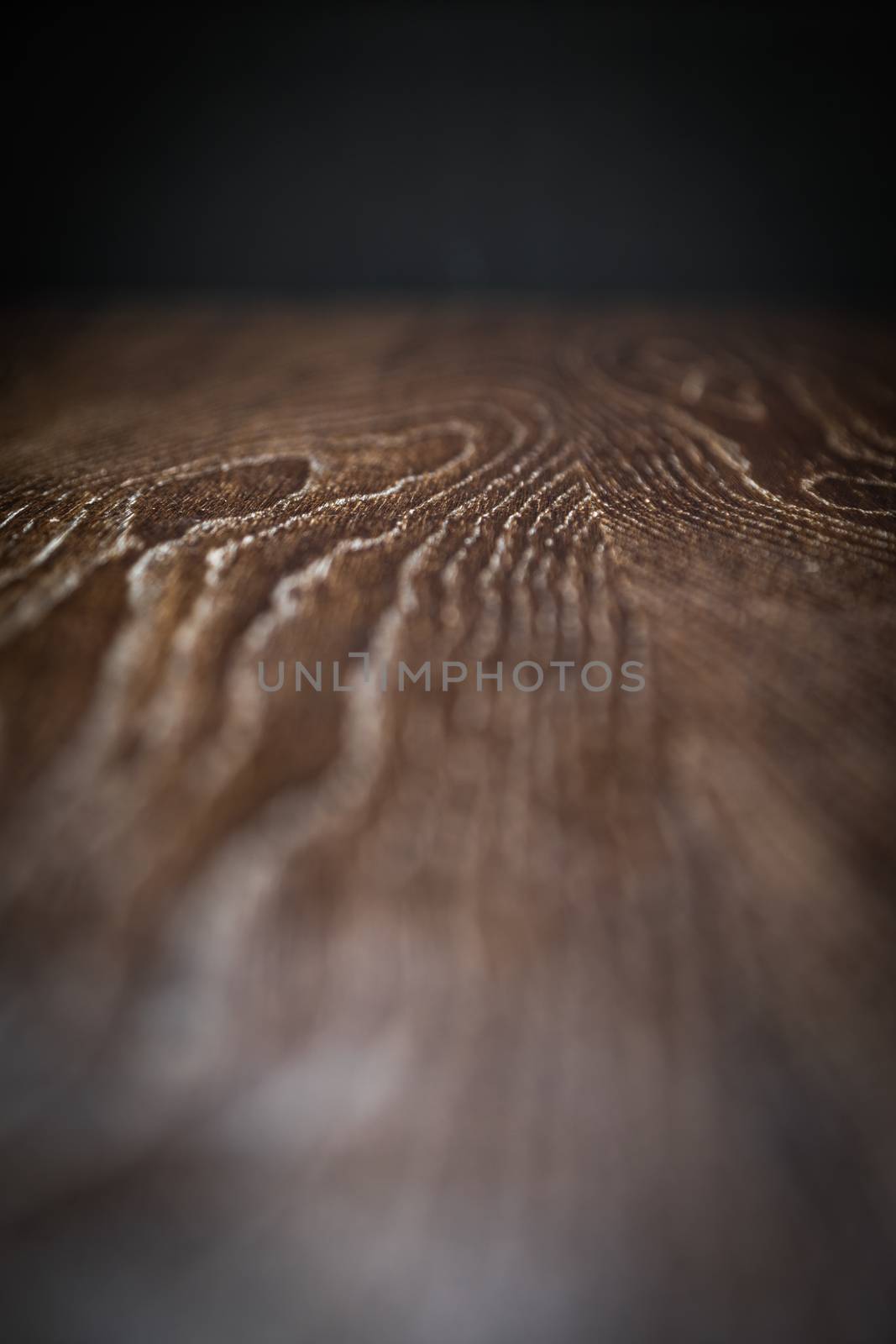 Wooden Background Surface with Narrow Depth of Field Fading to Black.