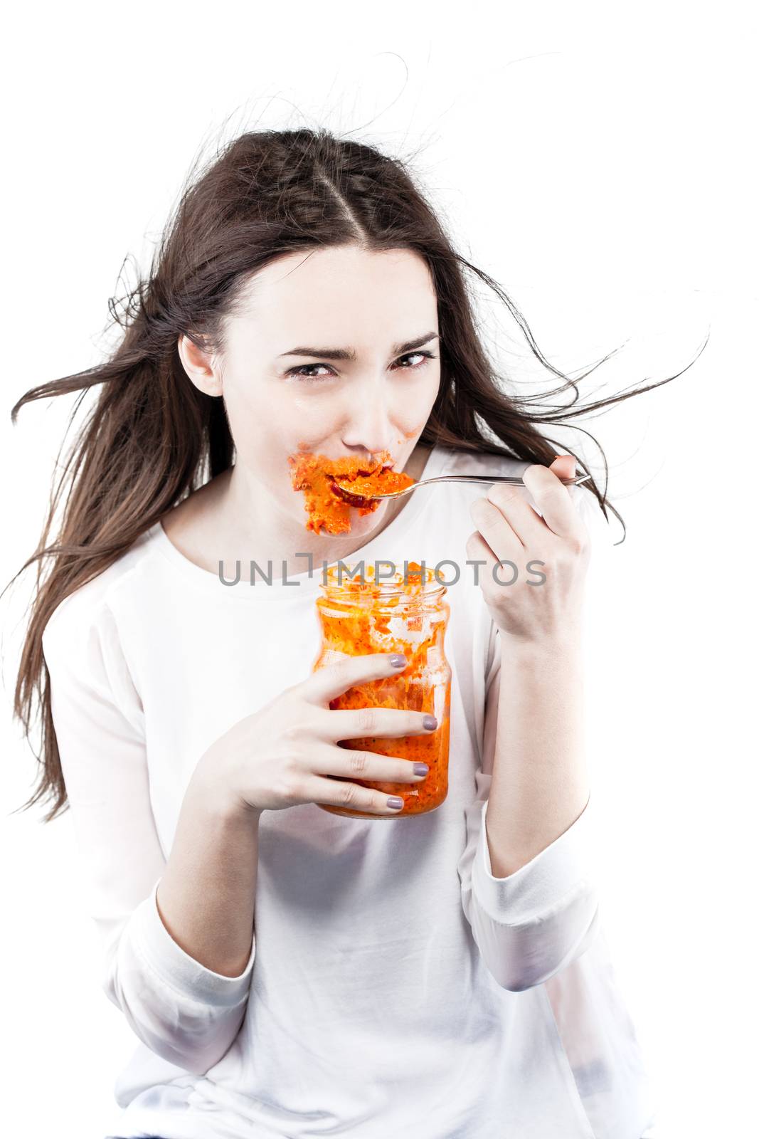 girl eating ajvar, roasted red pepper and eggplant from a jar, getting all messy around the mouth