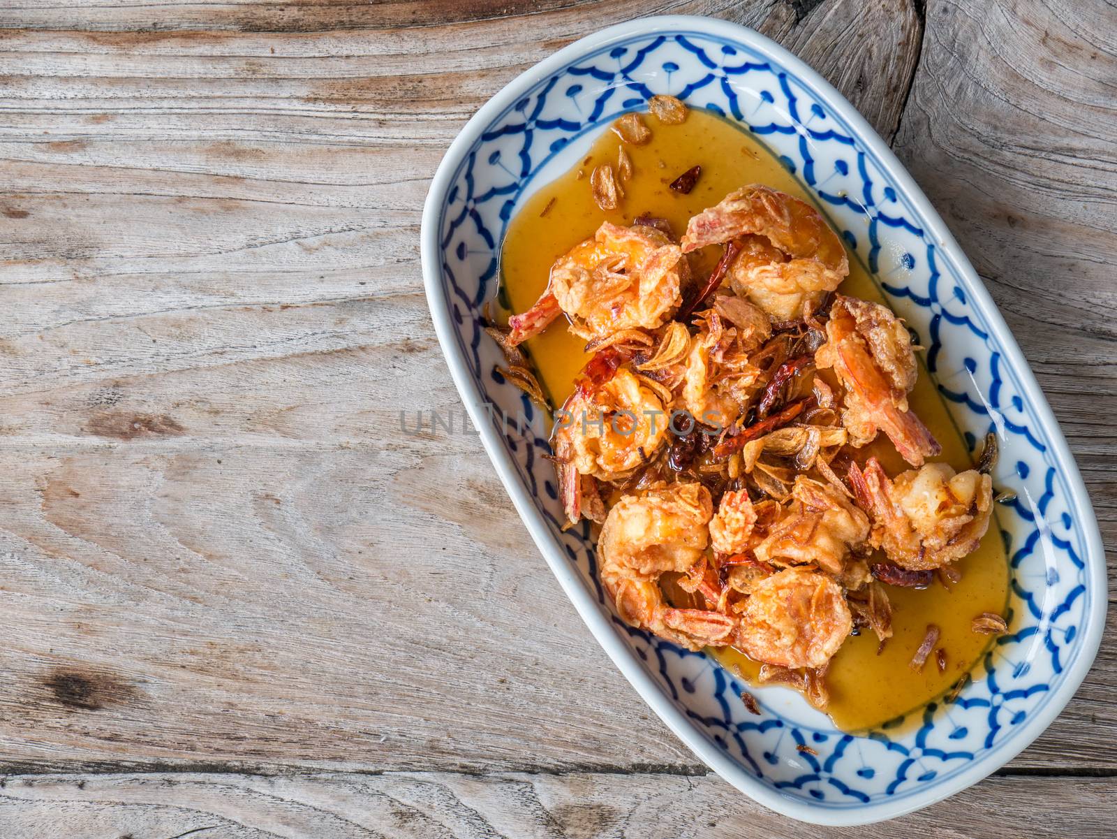 Fried Shrimp with Tamarind Sauce in white plate on wooden table with copy space