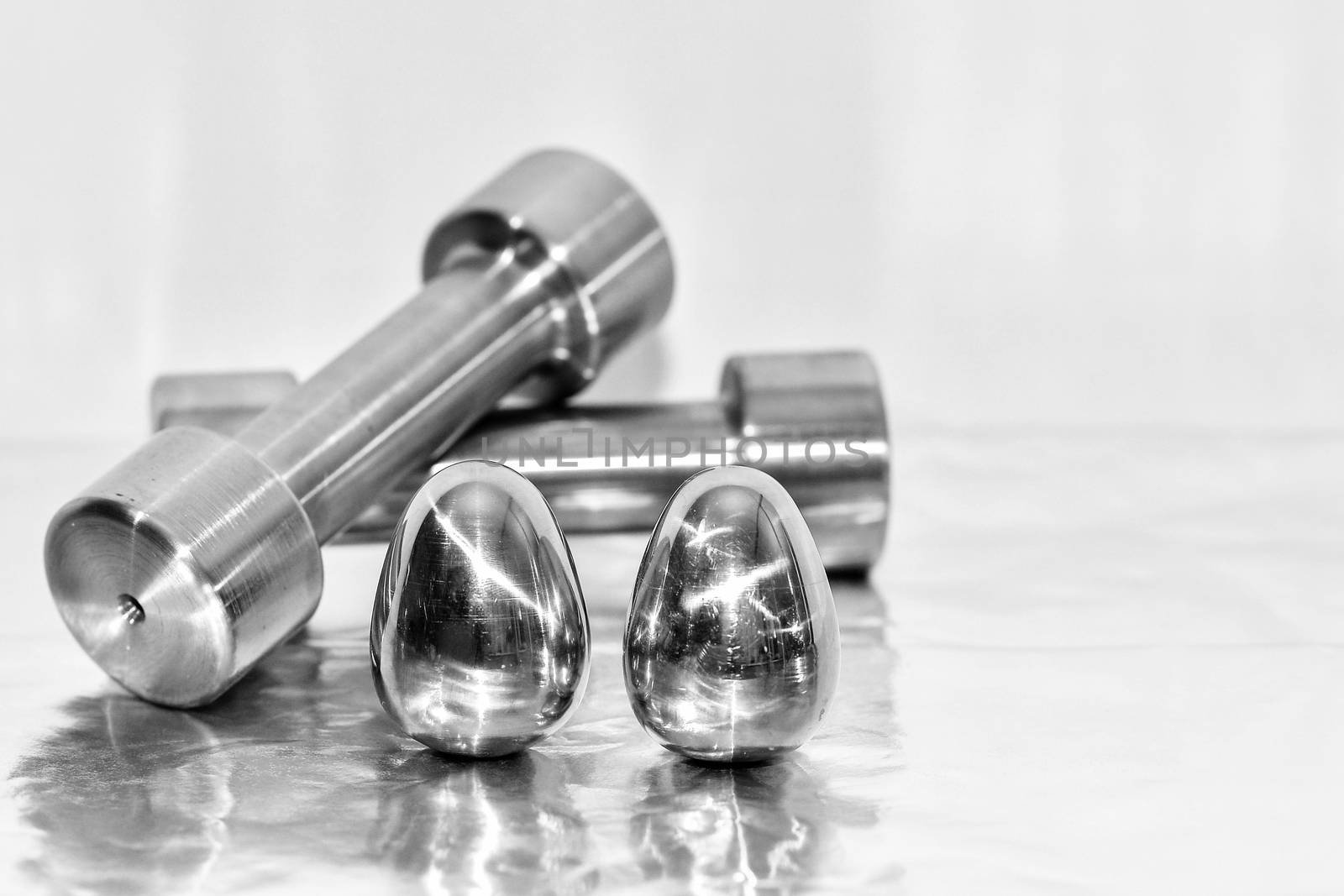 Metal dumbbells and steel eggs, the concept of sports training and the achievement of muscle strength.