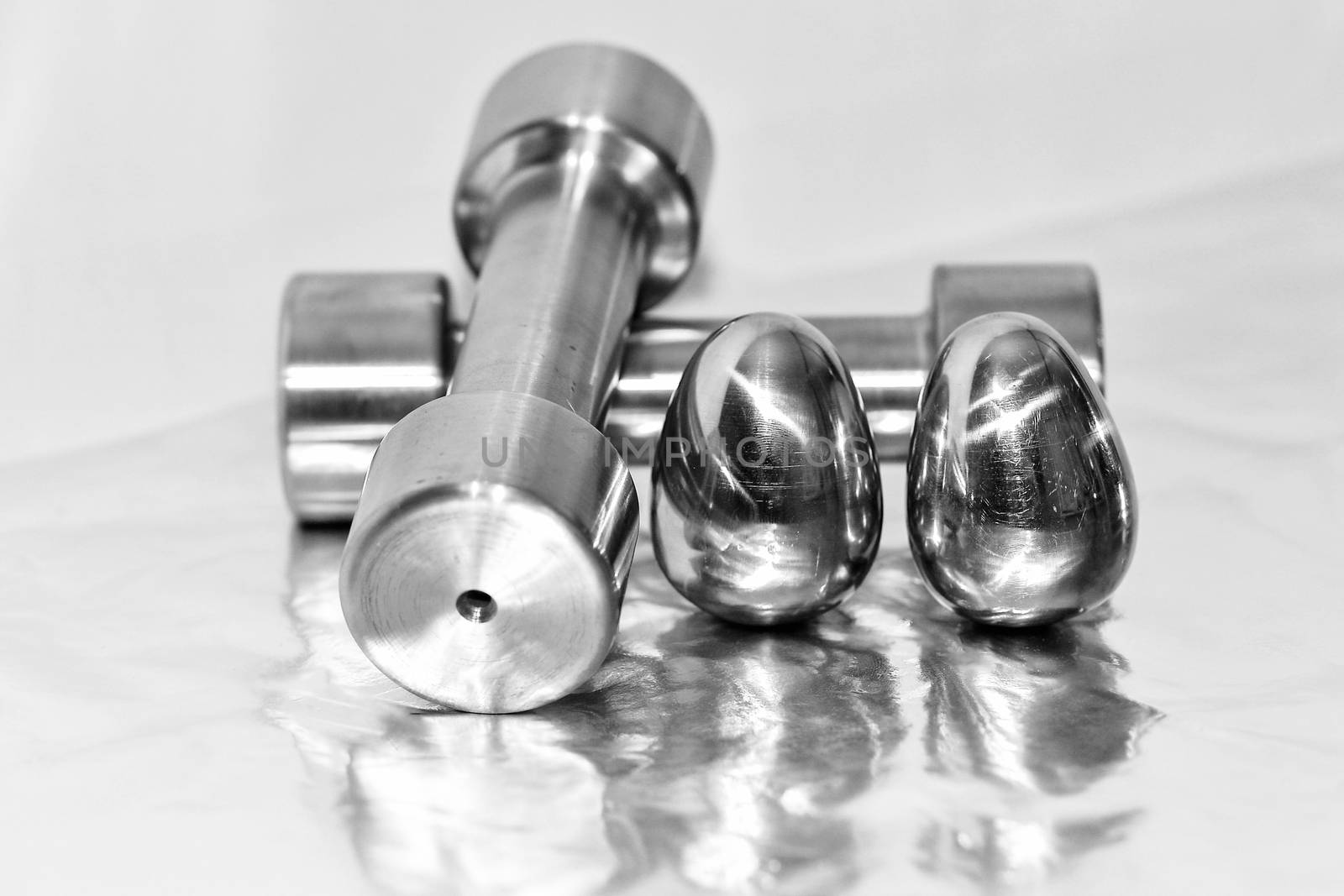 Metal dumbbells and steel eggs, the concept of sports training and the achievement of muscle strength.