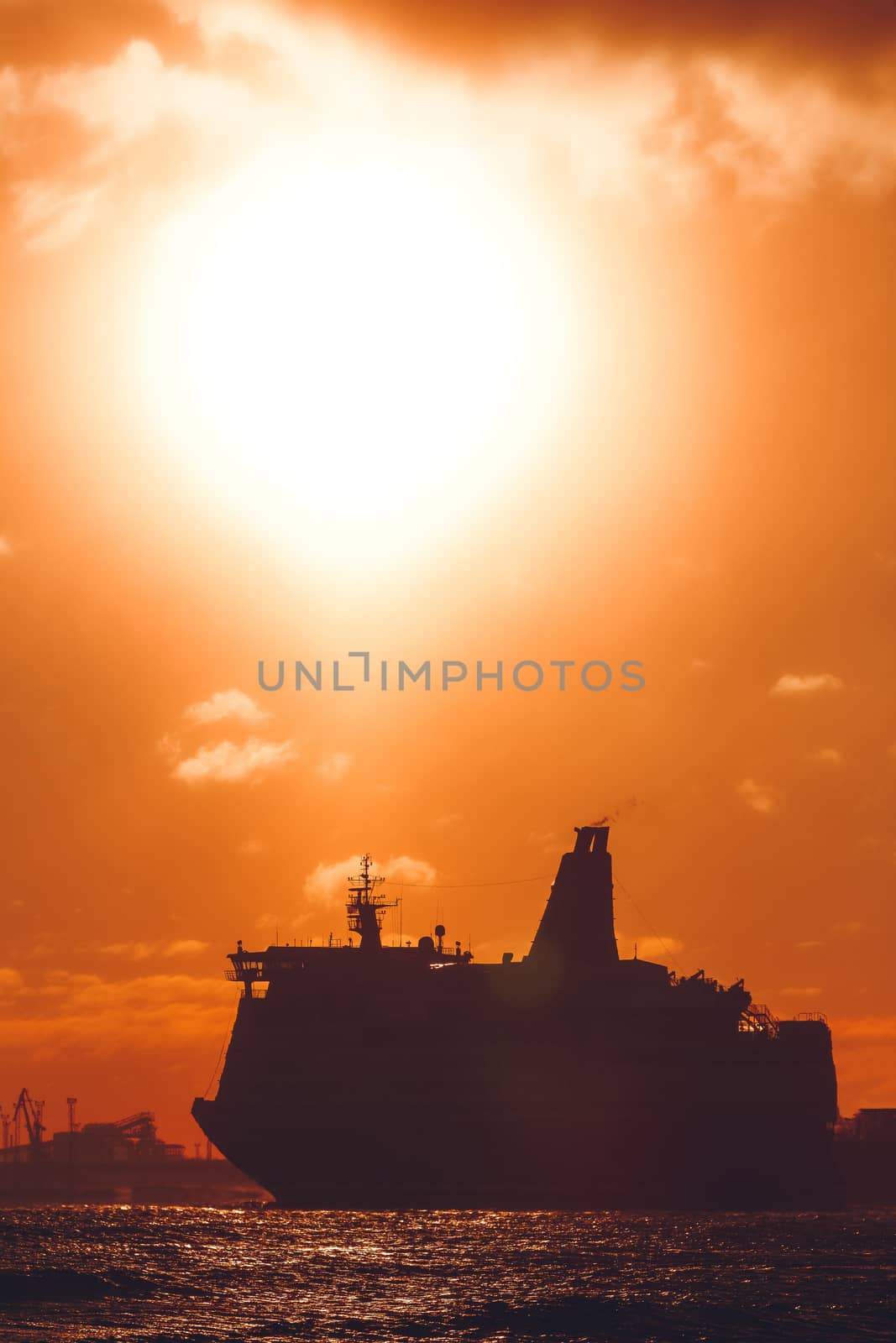 Hot orange winter sunrise against the cargo port