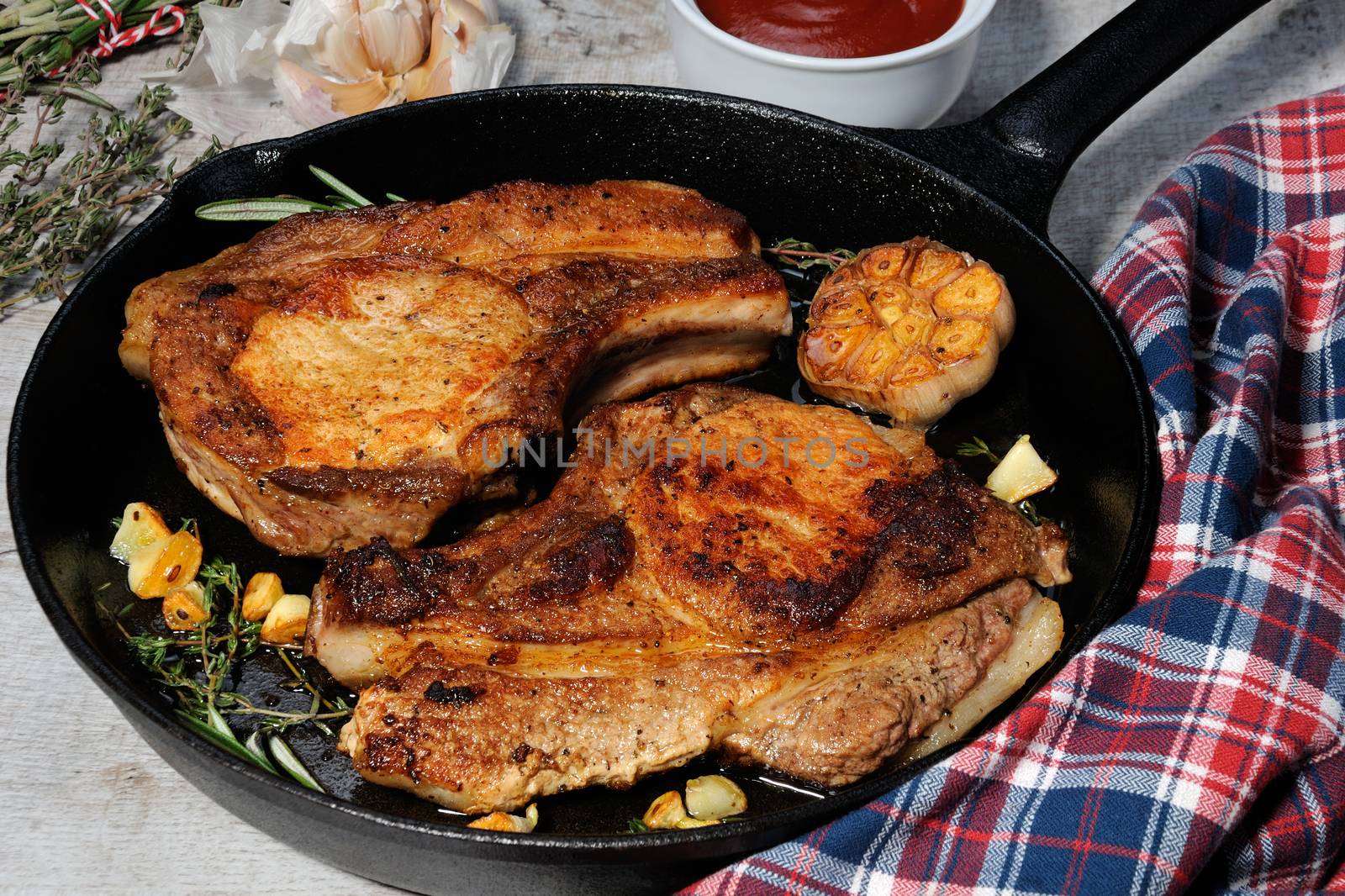 Roasted pork loin steak in a frying pan with tomato sauce 