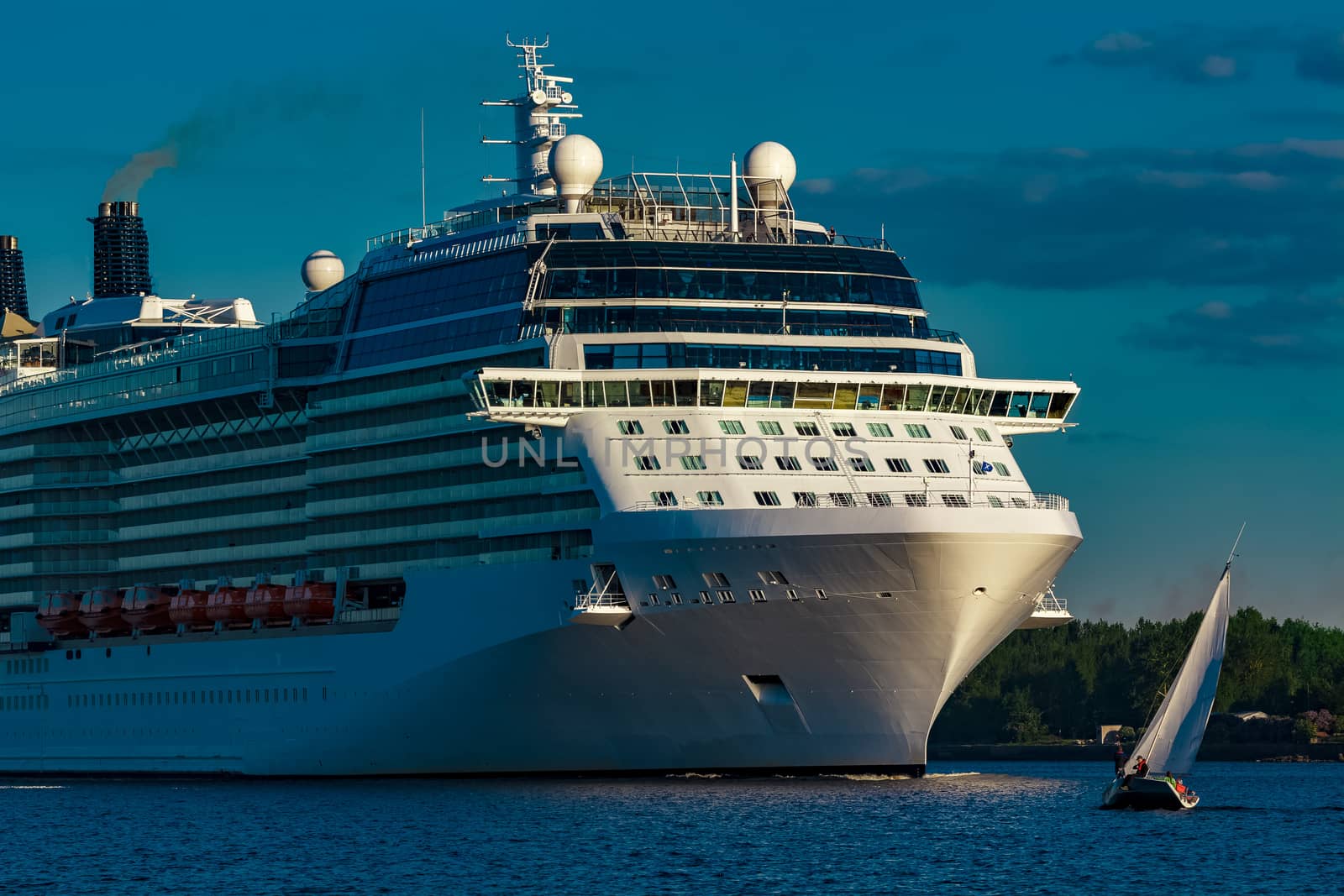 White giant brand new passenger ship moving in clear summer day