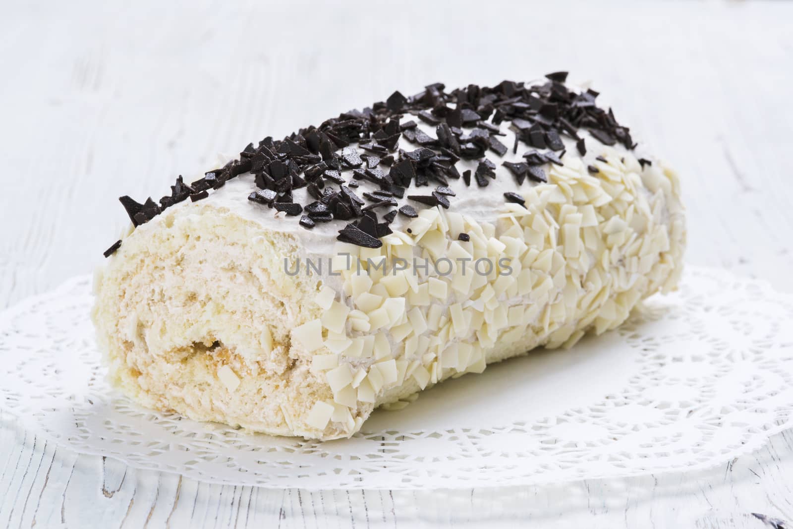 Biscuit roll with chocolate chips on a table, selective focus
