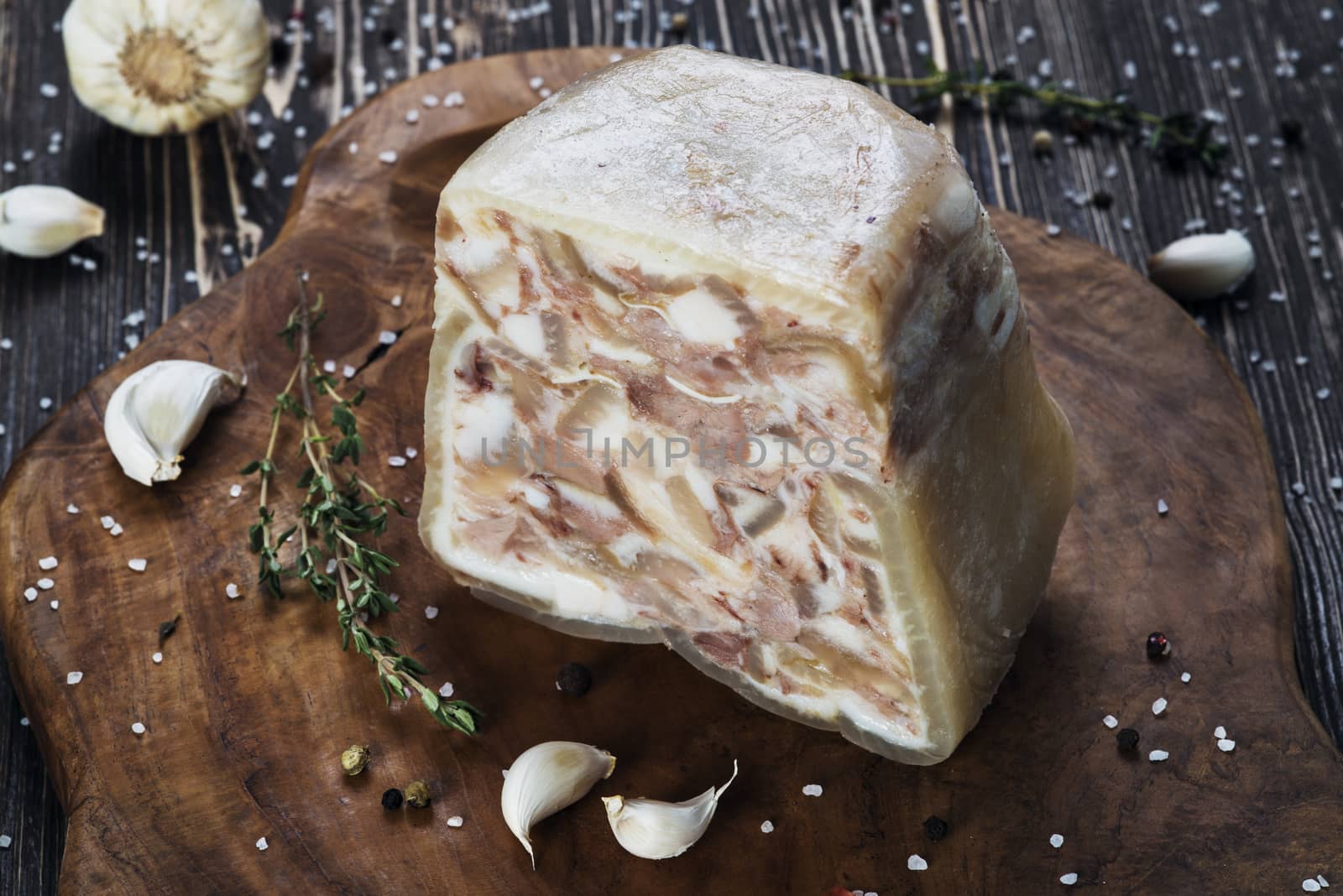 Headcheese on a slate cutting board on wooden background