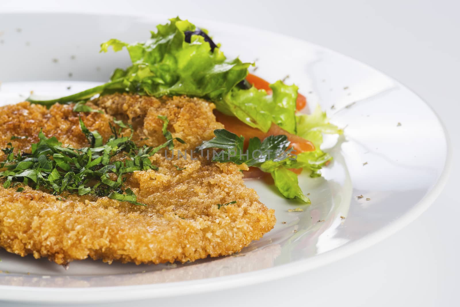 Crispy baked  pork chop served with salad on a plate