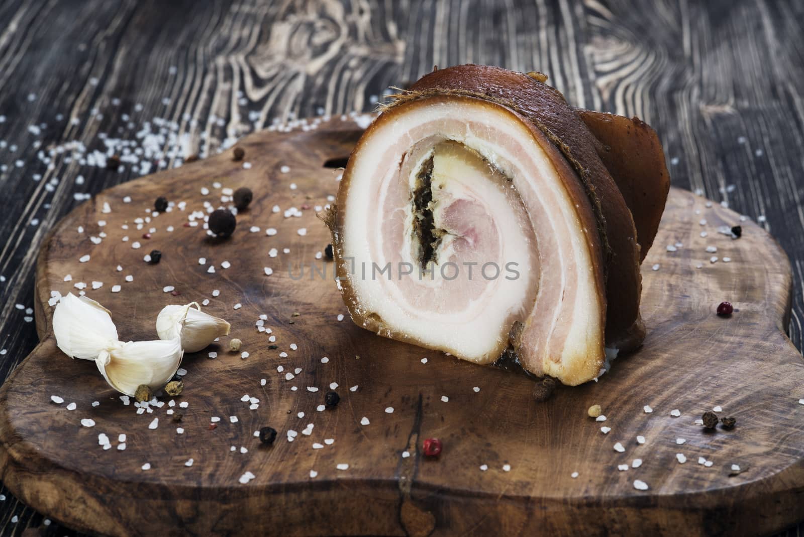 Lard roll with salt and garlic, wooden background