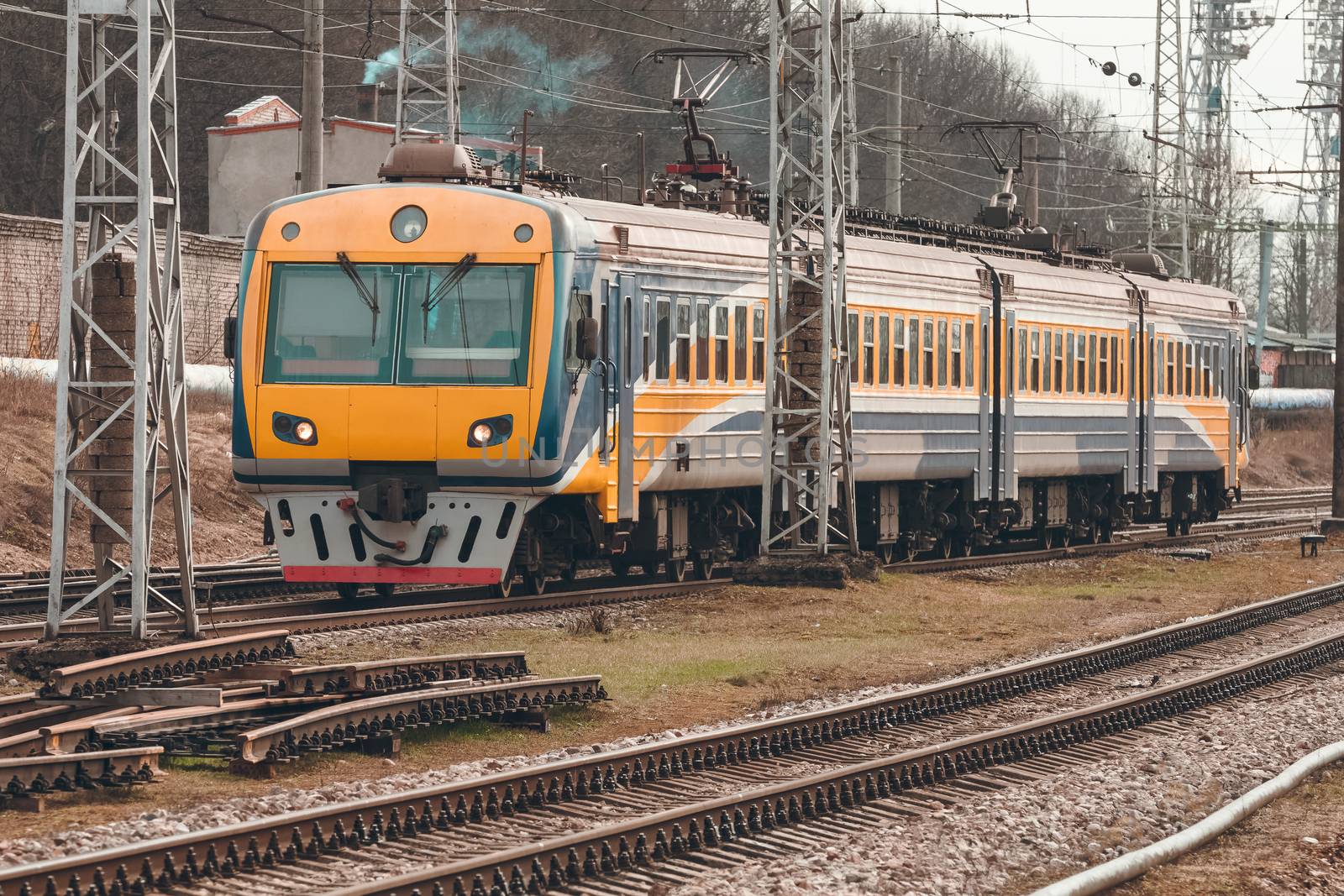 Yellow modern passenger electric train moving at the old terminal