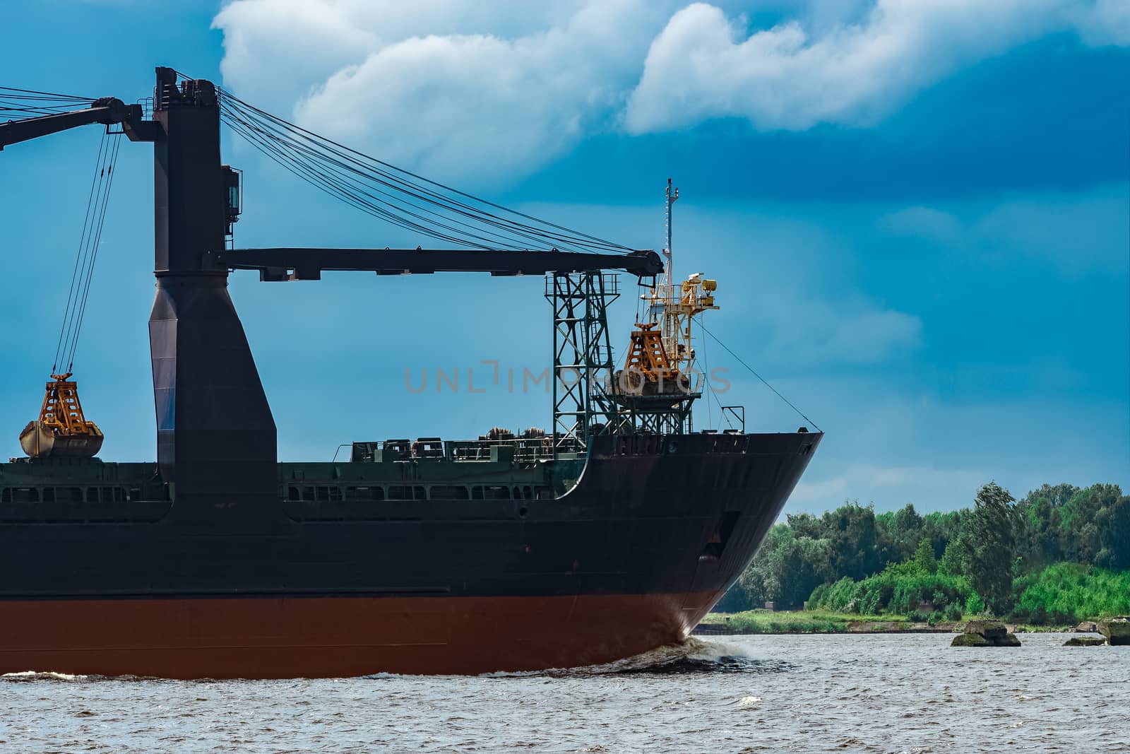 Merchandise import. Large blue cargo ship moving to Riga port