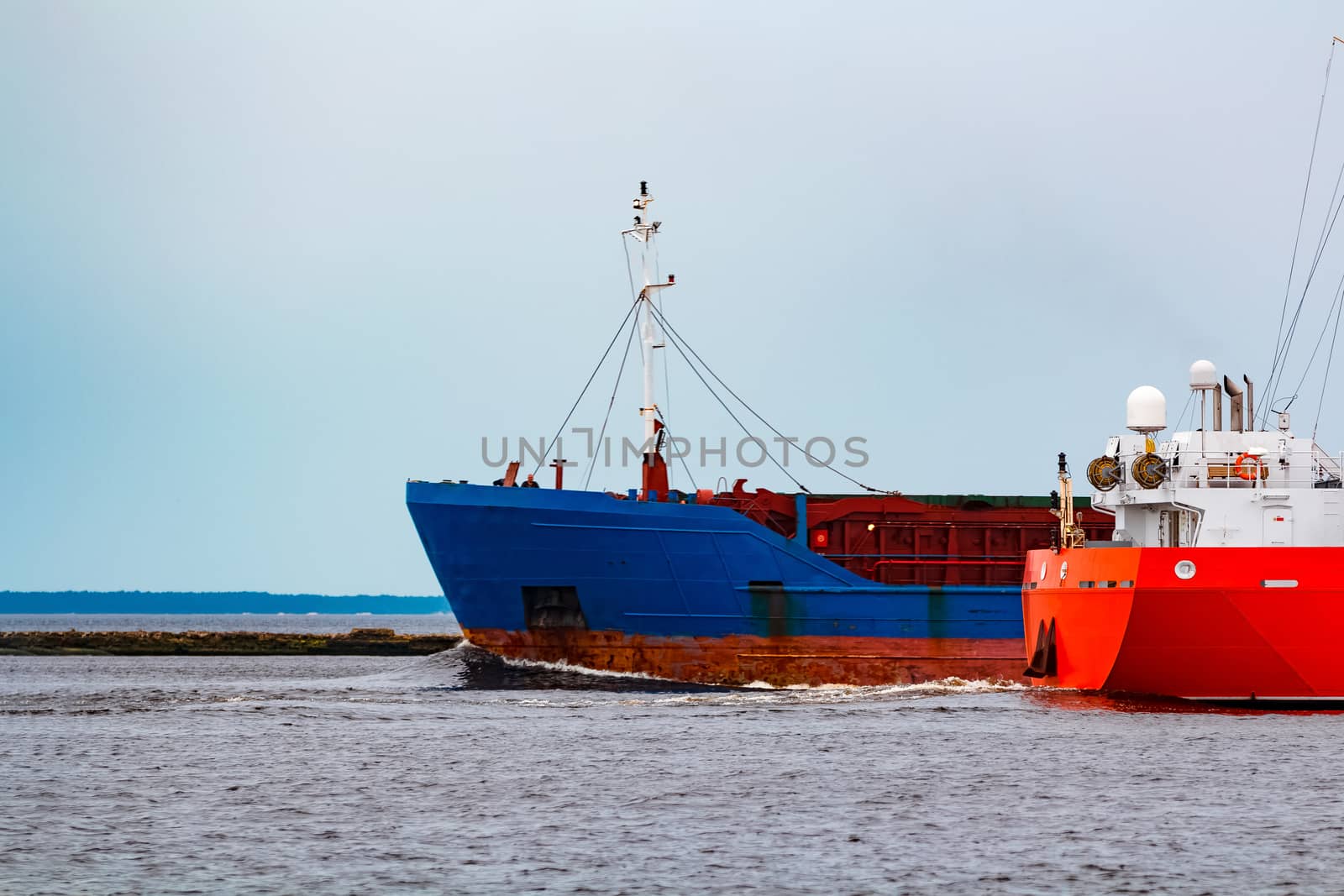 Merchandise import. Large blue cargo ship moving to Riga port