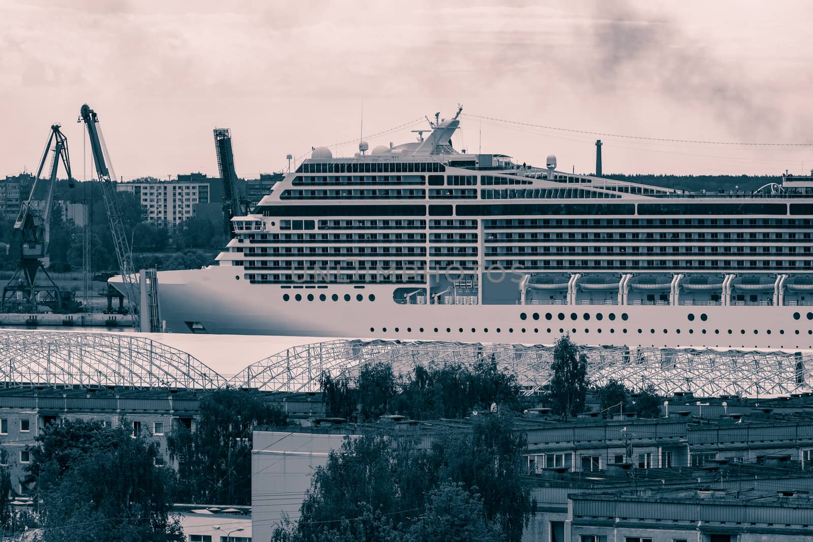 Large cruise liner sailing past the cargo port. Monochrome