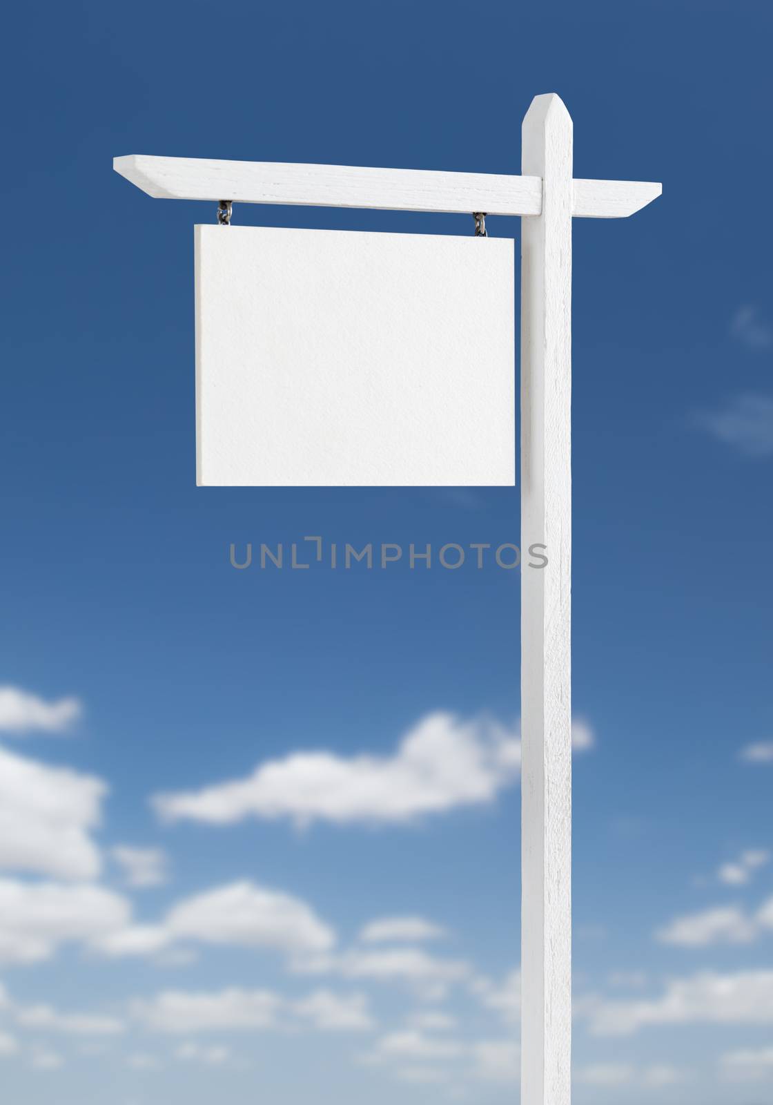 Blank Real Estate Sign Over A Blue Sky with Clouds. by Feverpitched