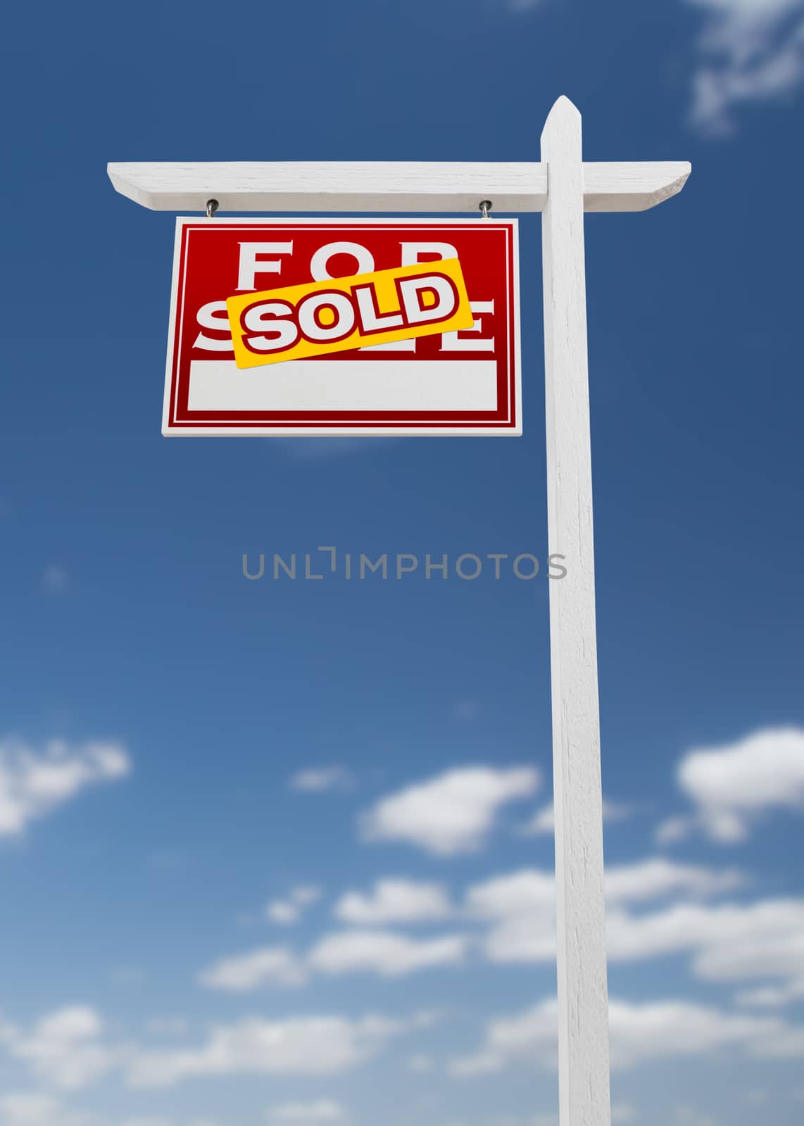 Left Facing Sold For Sale Real Estate Sign on a Blue Sky with Clouds.