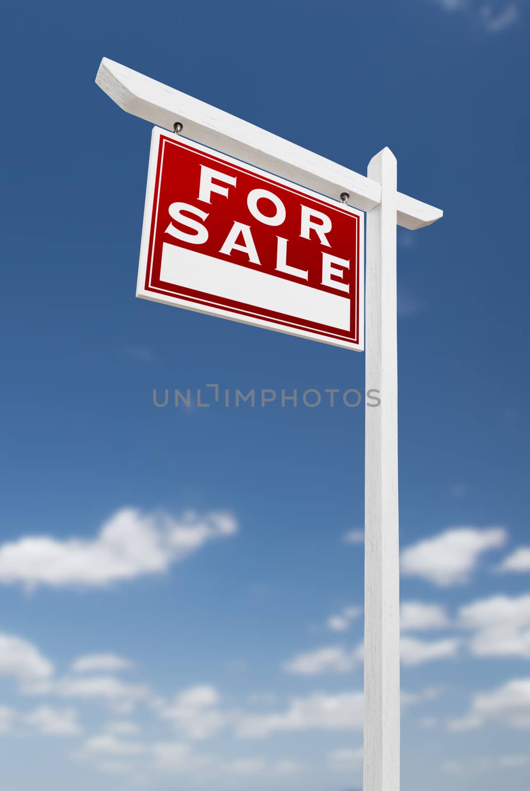 Left Facing For Sale Real Estate Sign on a Blue Sky with Clouds.