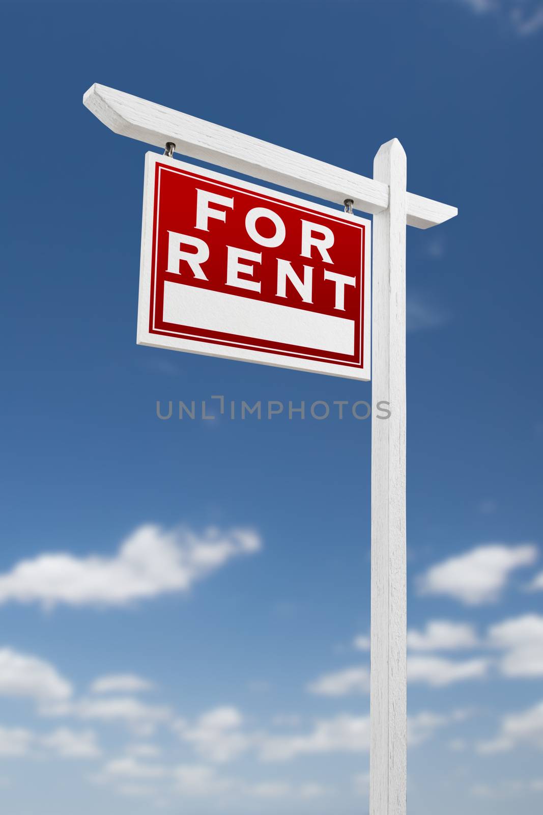 Left Facing For Rent Real Estate Sign on a Blue Sky with Clouds.