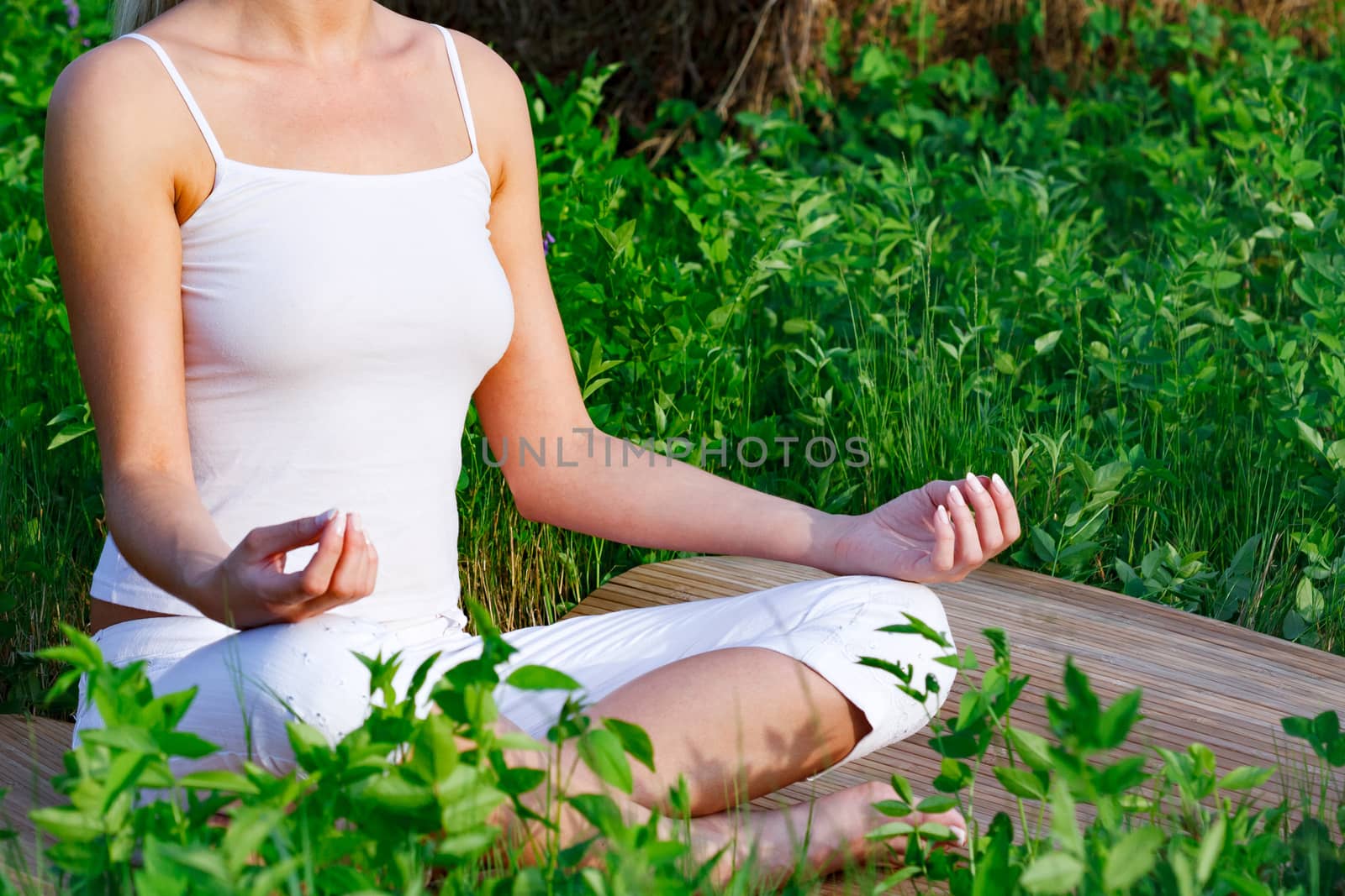 Yoga woman sitting in green grass by Nobilior