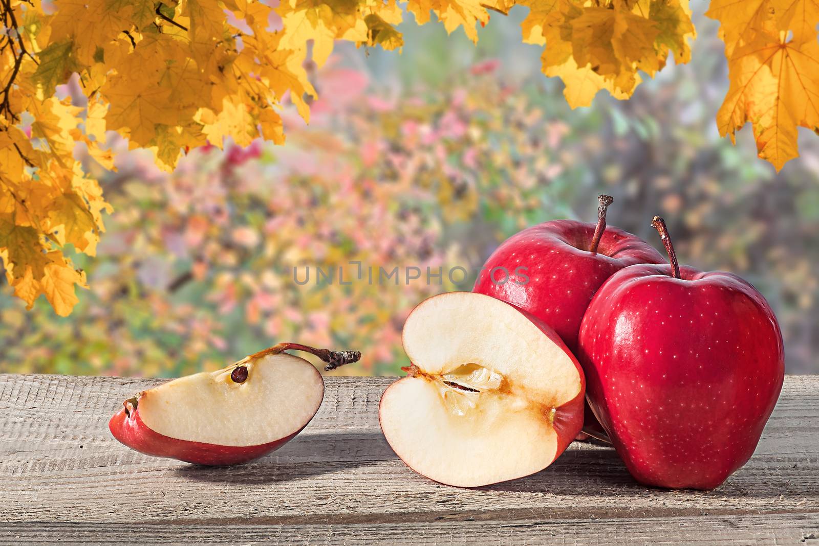 Several apples on a wooden table. Blurred background. Half and a quarter of an apple.