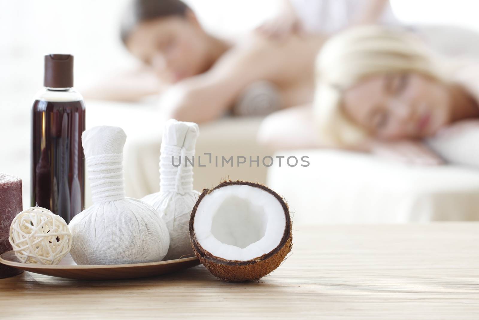 Spa massage tools and women getting massage on background