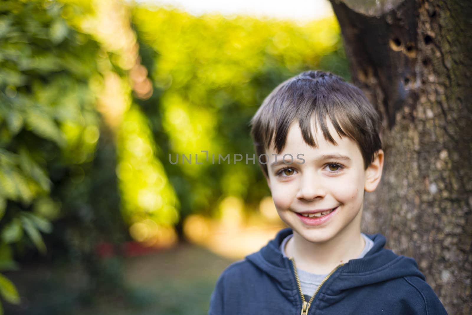 portrait of 7 year old boy outdoor in the garden in winter