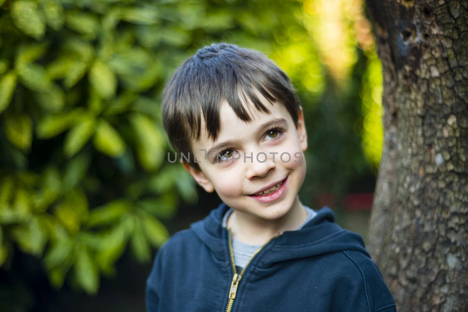 portrait of 7 year old boy outdoor in the garden in winter