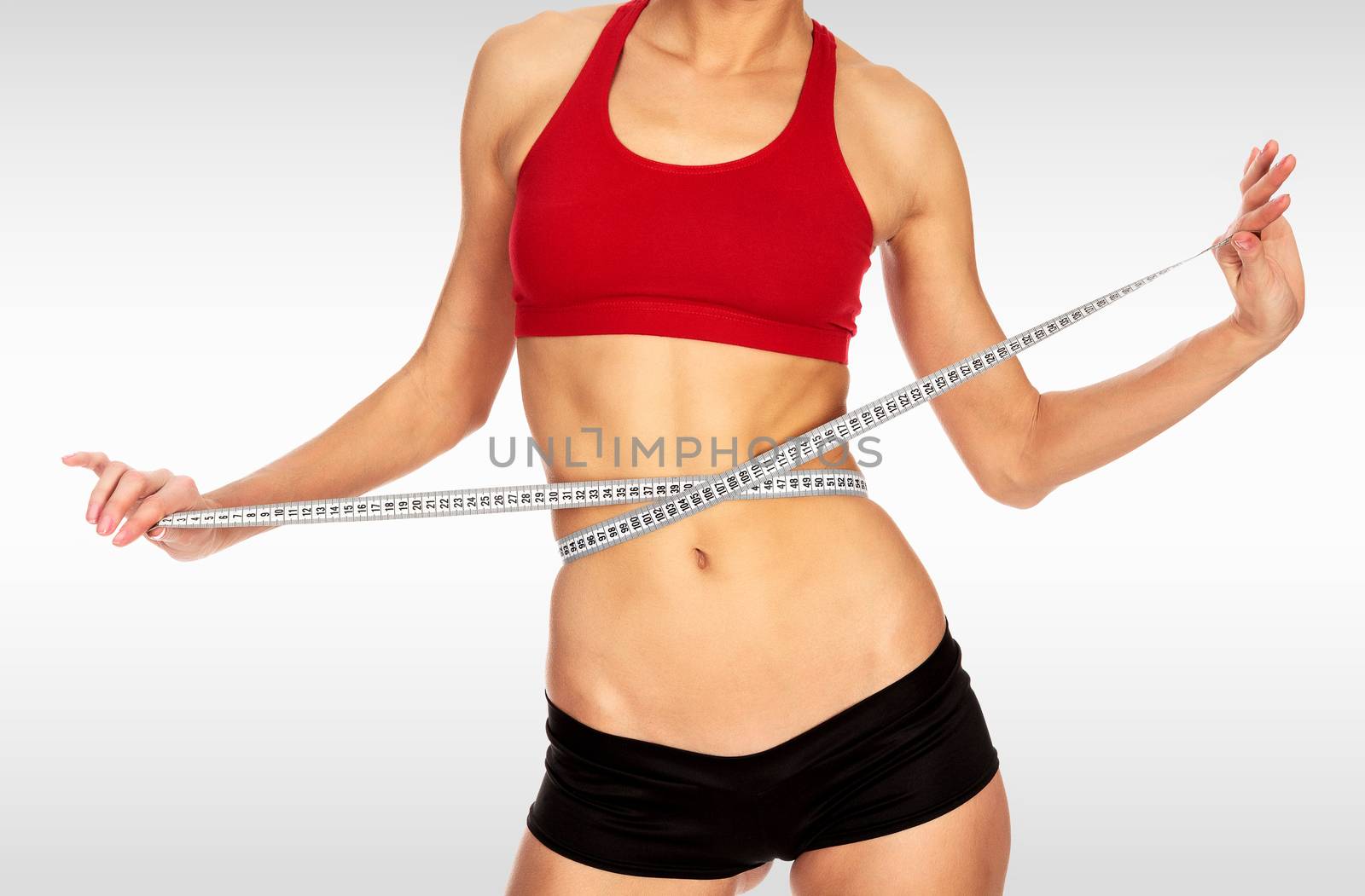 Fitness woman with a tape measure against a grey background with by Nobilior