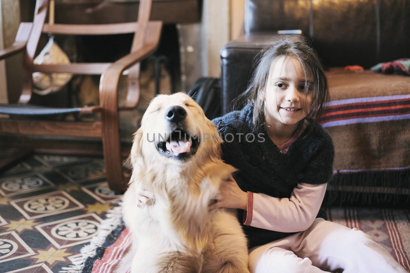 little girl at home with her golden retriever dog have affectionate gestures