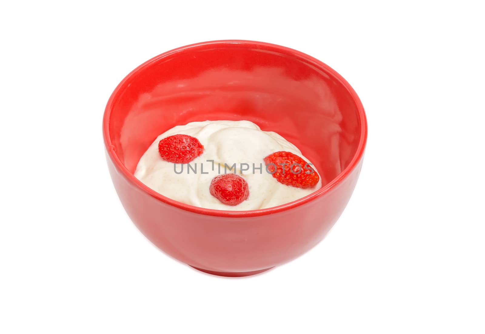 Fresh berries of the strawberry with whipped cream in red ceramic bowl on a light background
