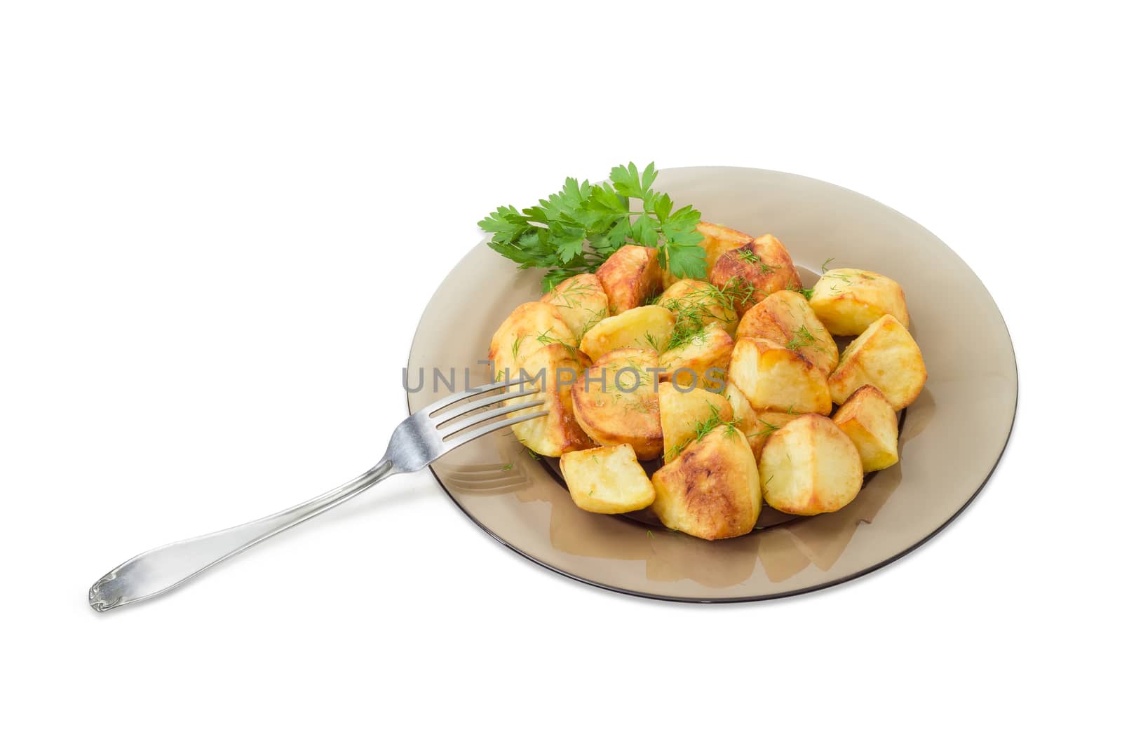 Serving of the country style fried potatoes sprinkled by chopped dill and twig of parsley on dark glass dish and fork on a light background
