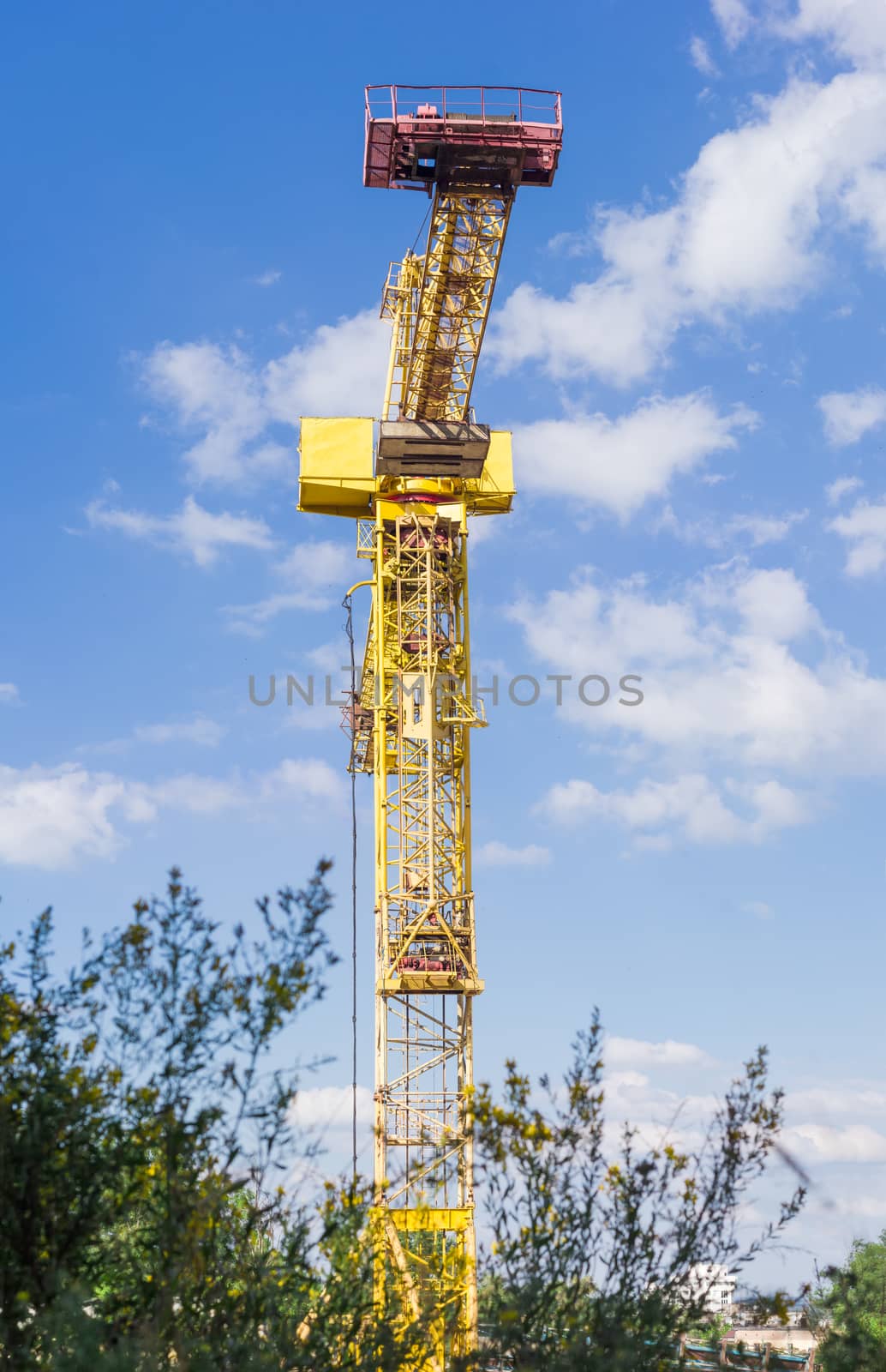 Tower construction crane with latticed boom on a background of the sky
