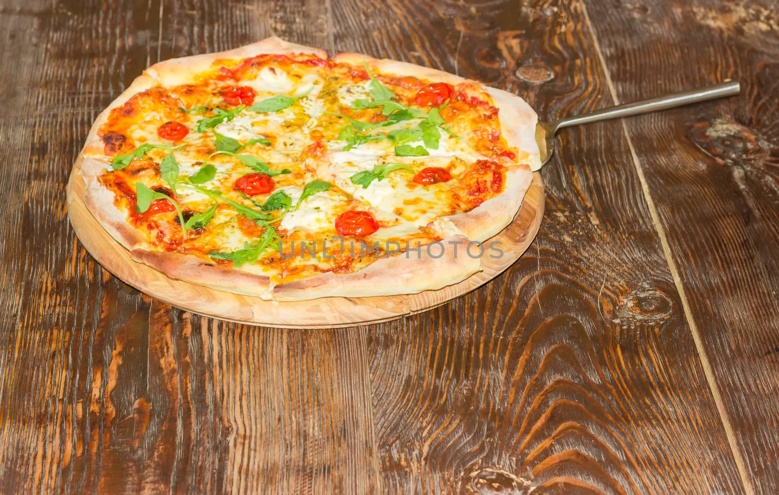 Pizza with pizza spatula on the old wooden table by anmbph