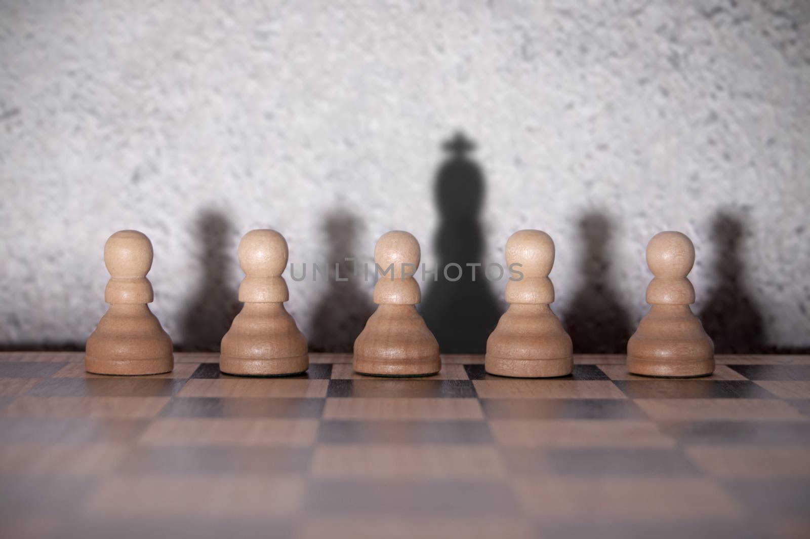 Chess king shadow standing out in a row of pawns