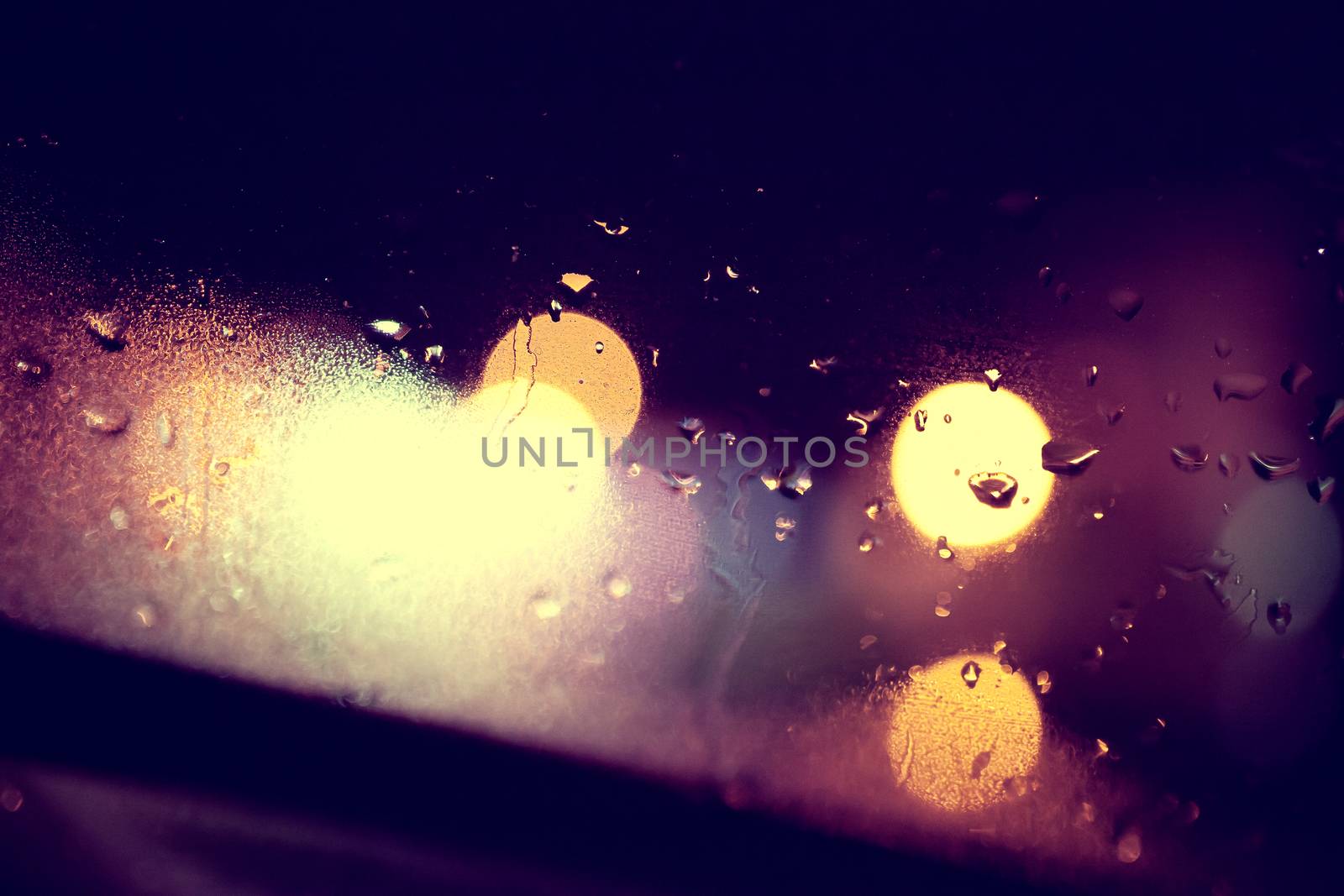 Wet window background and city lights.Rainny night through the glass